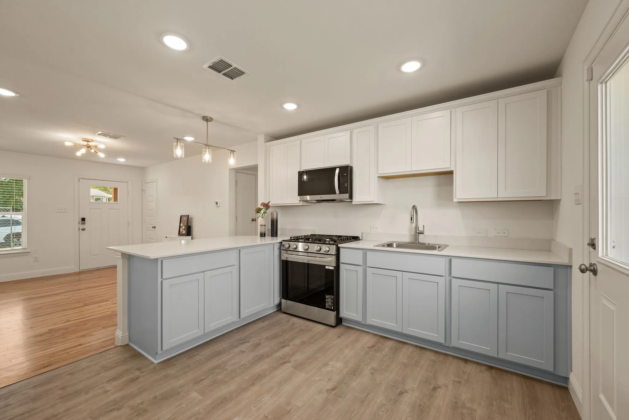 Sleek stainless steel and black appliances include Gas Range and Microwave; Under sink is pre-wired for a disposal