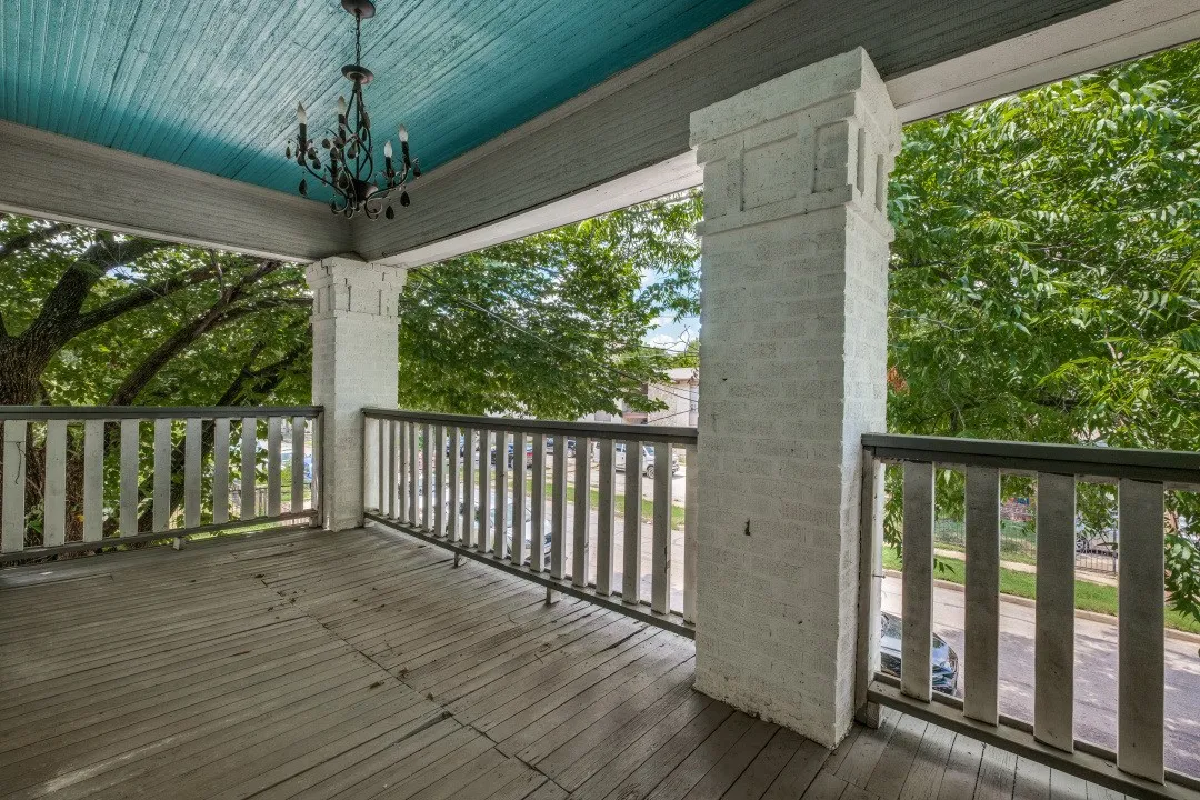 Expansive porch with wood-finish flooring, a decorative chandelier, and a painted beadboard ceiling