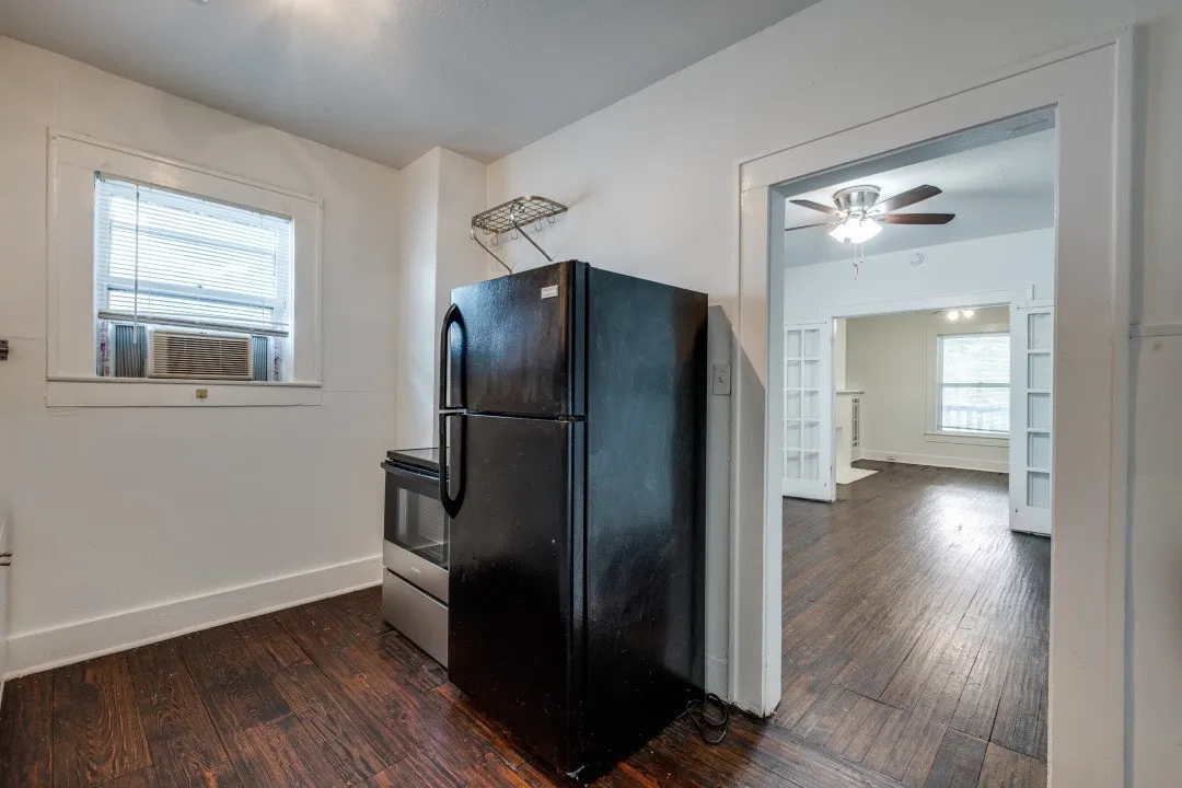 Wood-finish flooring throughout, with a window-mounted air conditioning unit