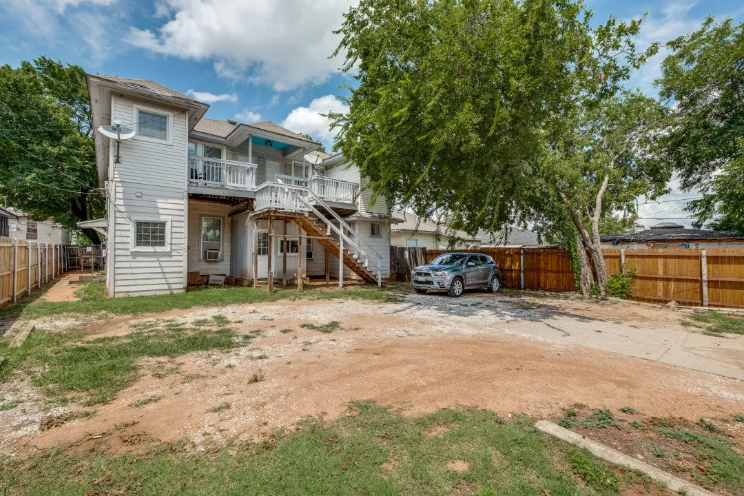 Exterior with white siding and multiple balconies featuring white railings