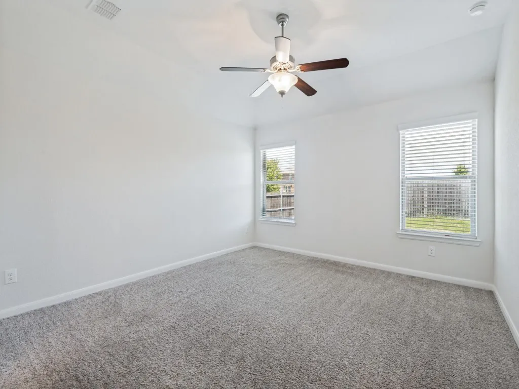 Recessed lighting, ceiling fan with integrated light fixture, dual windows with blinds, and neutral carpeting