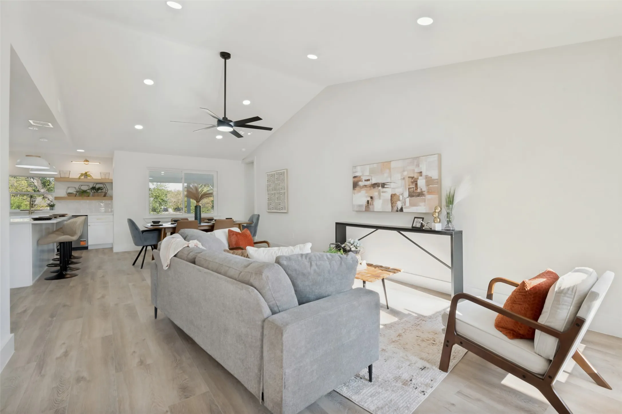 Vaulted ceiling with recessed lighting, wood-finish flooring, modern ceiling fan, open concept kitchen, and dining area