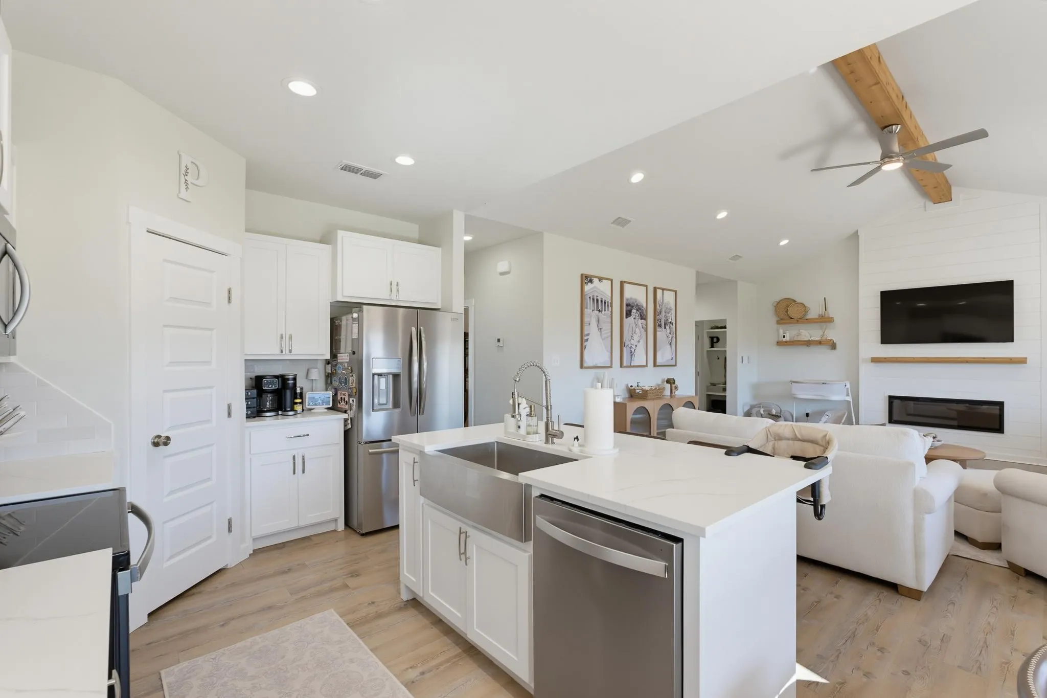 Kitchen with white cabinetry, stainless steel appliances, and a central island with a farmhouse sink