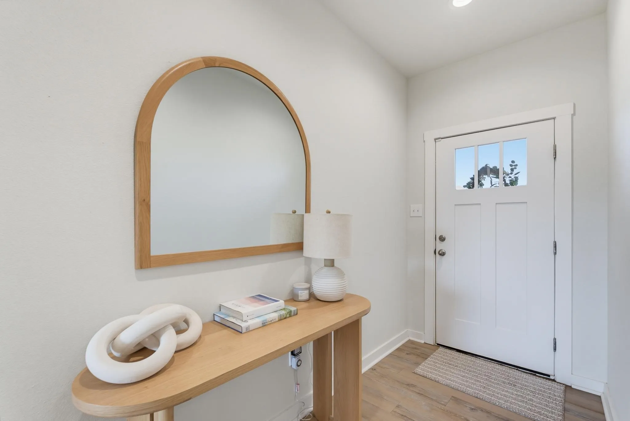 Entryway featuring a white paneled door with divided lite glass, a recessed ceiling light, and wood-finish flooring