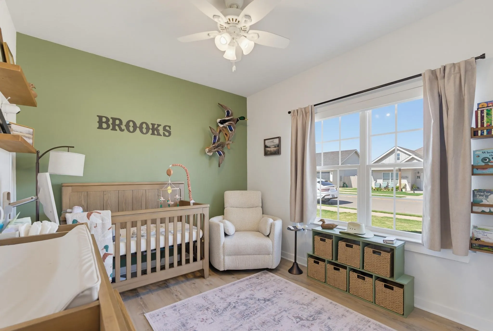 Wood-finish flooring, a ceiling fan with light fixture, and a large window with white muntins