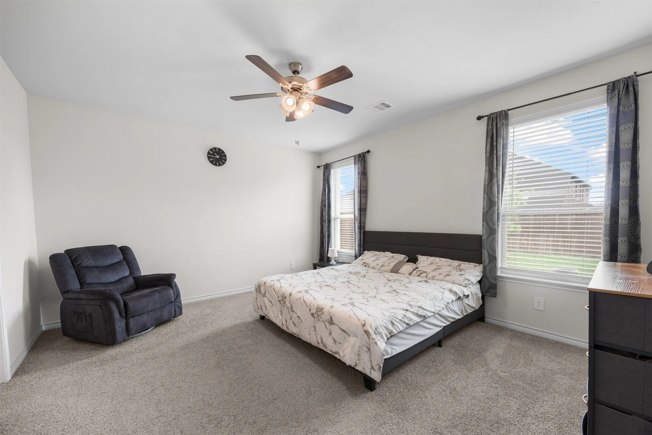 Carpeted flooring, white walls, and a ceiling fan with integrated lighting
