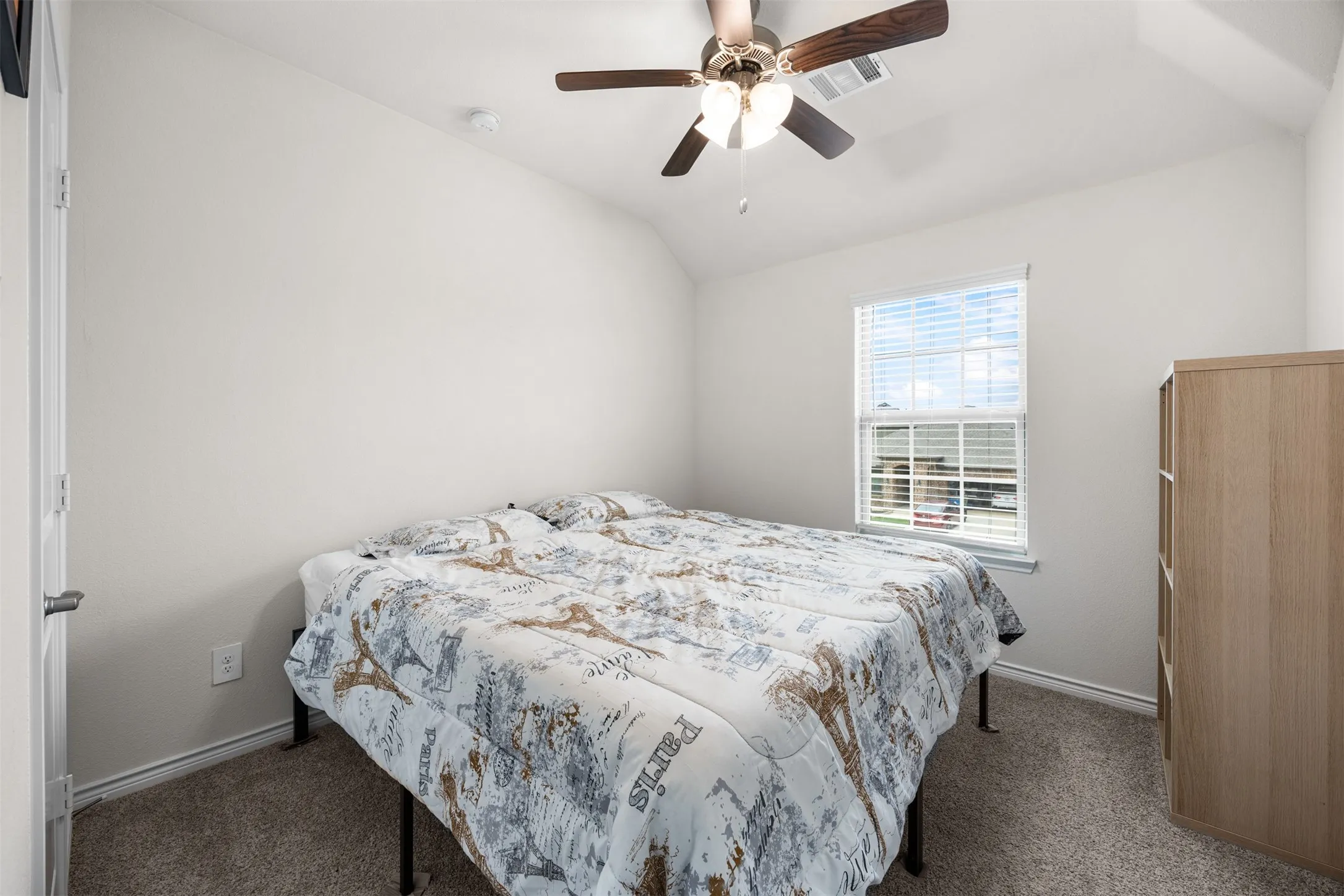 Carpeted flooring, vaulted ceiling, and a ceiling fan with integrated lighting