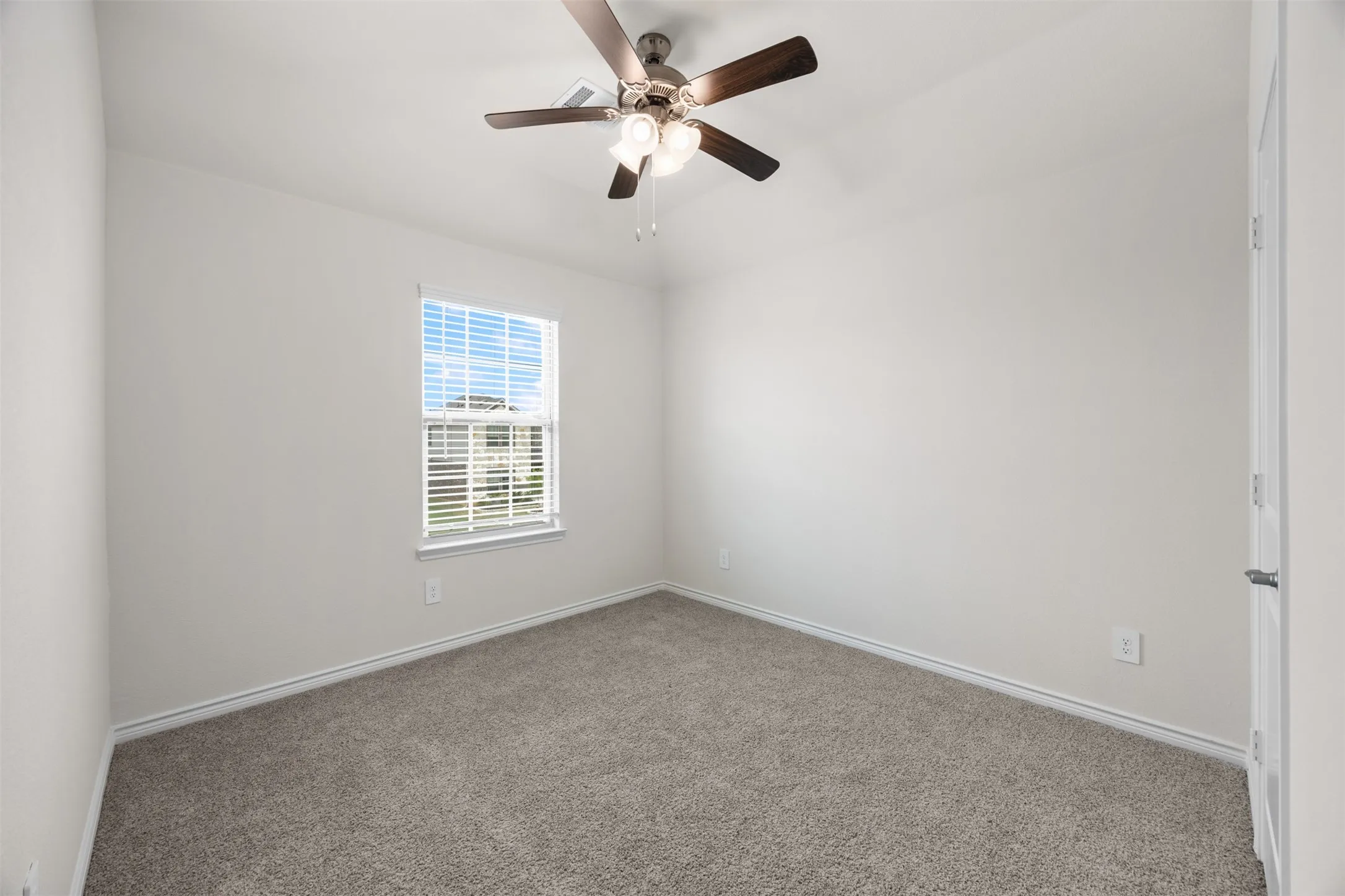 Neutral-toned carpeting, white walls, and a window with blinds