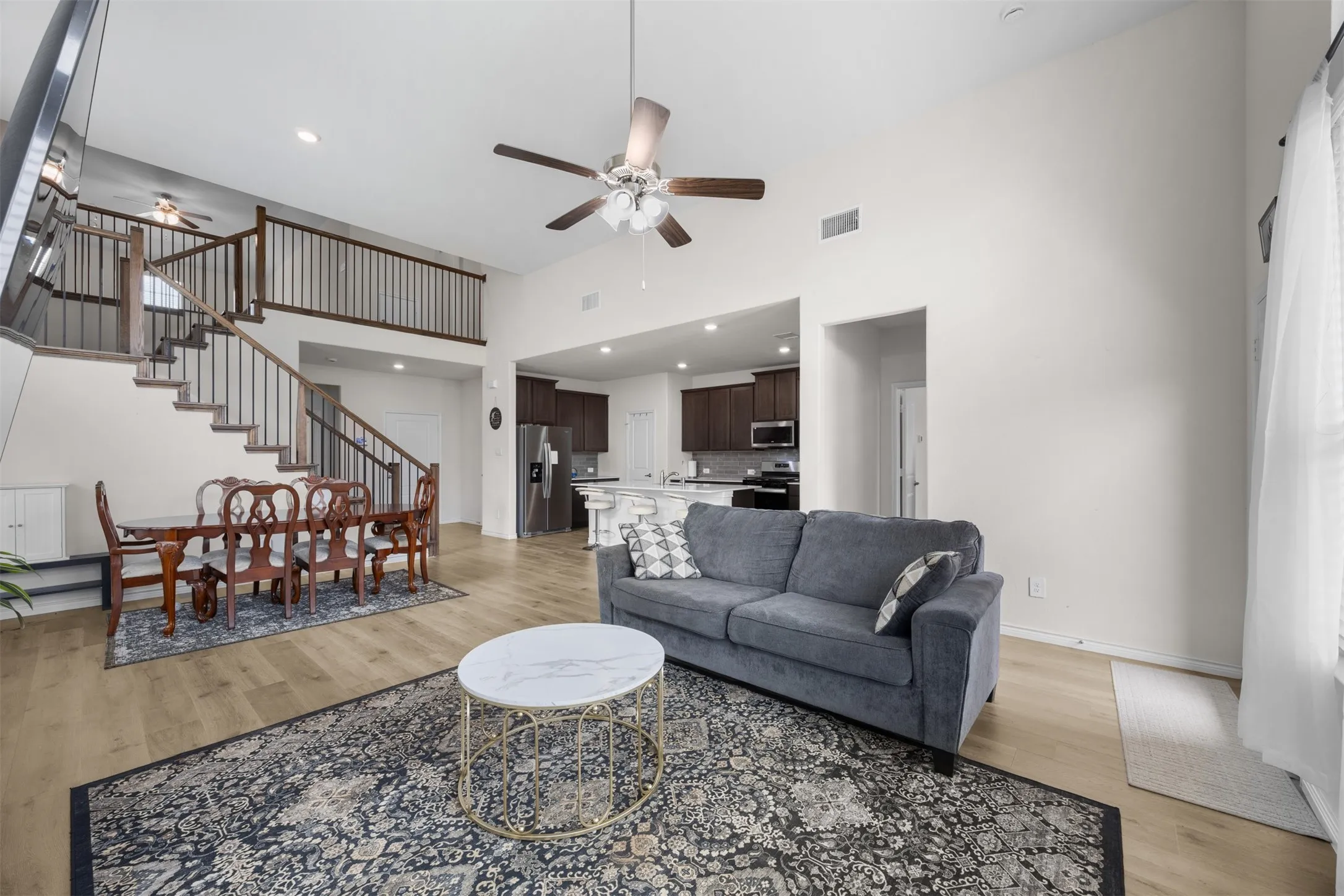 Vaulted ceiling, open-concept design, wood-finish flooring, built-in staircase, kitchen with built-in cabinetry