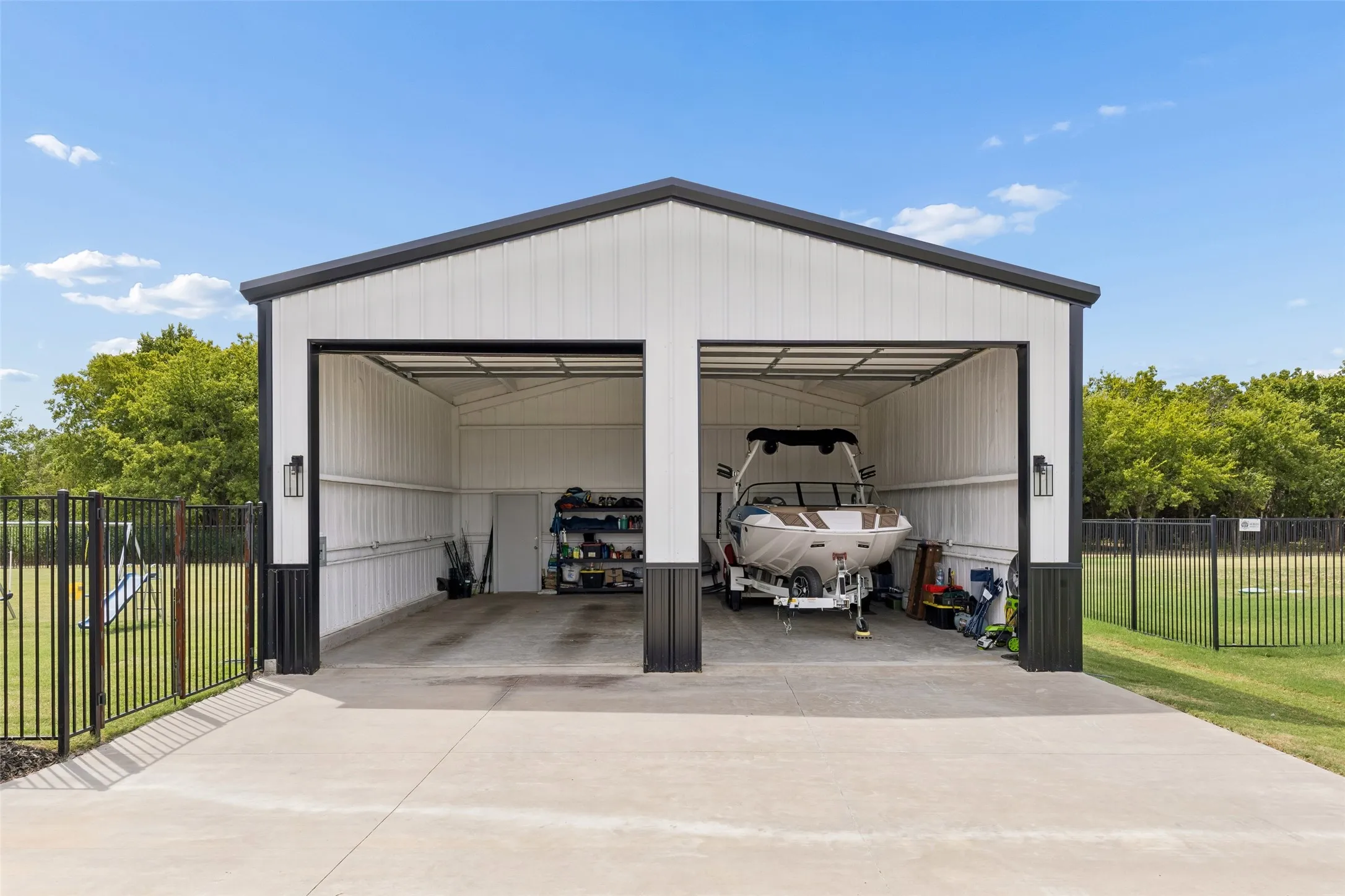 Detached 30x30 garage featuring two bays with 12x12 doors, foam insulation, black sectional doors and exterior wall sconces