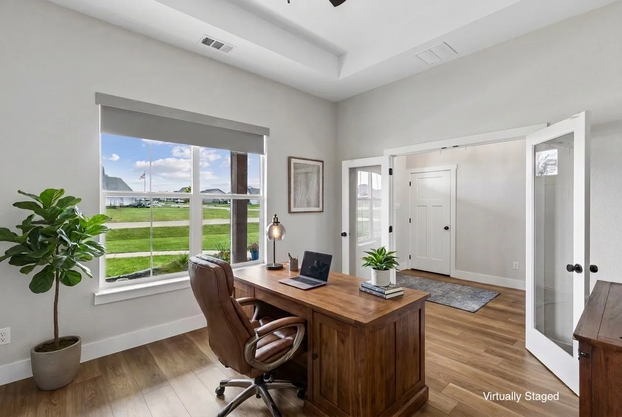 Office space featuring wood-finish LVP flooring, a tray ceiling, a large window, and French doors. This has been virtually staged.