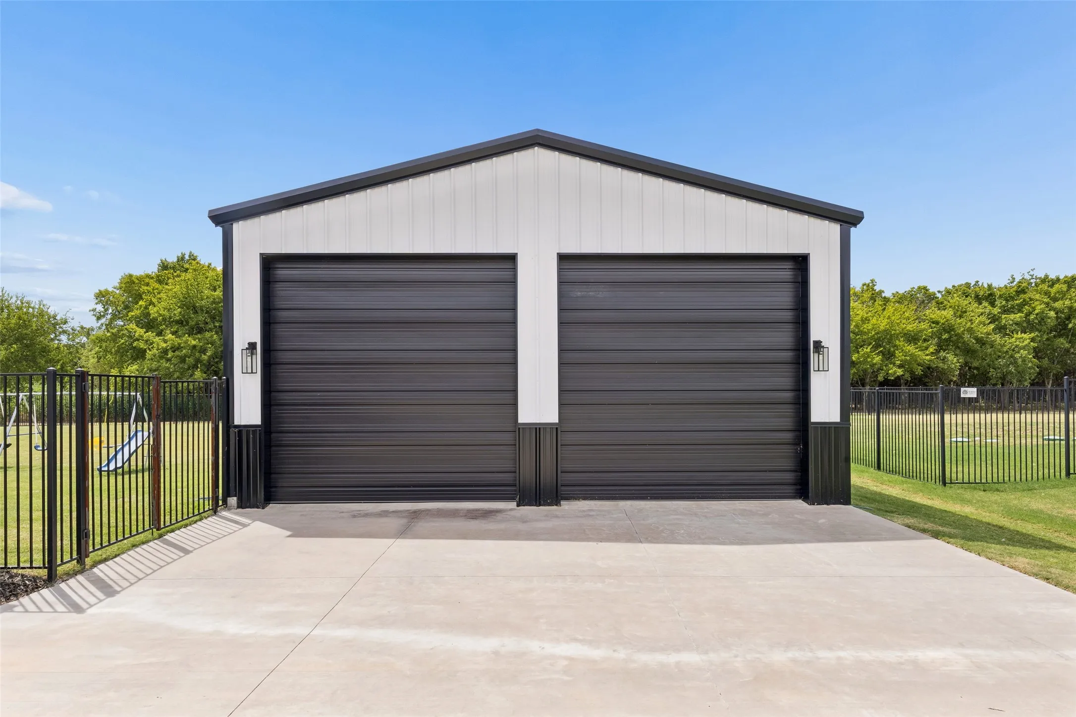 Detached 30x30 garage featuring two bays with 12x12 doors, foam insulation, black sectional doors and exterior wall sconces