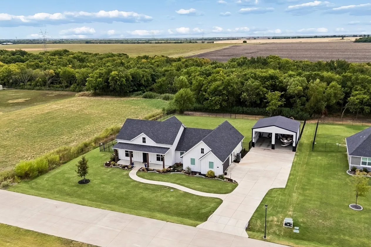 Modern farmhouse exterior with dark shingle roofing, expansive green lawn, and a detached 30x30 garage for RV or boat.