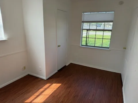 Unfurnished bedroom featuring baseboards and wood finished floors