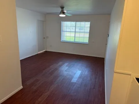 Living room with baseboards, ceiling fan, and wood finished floors