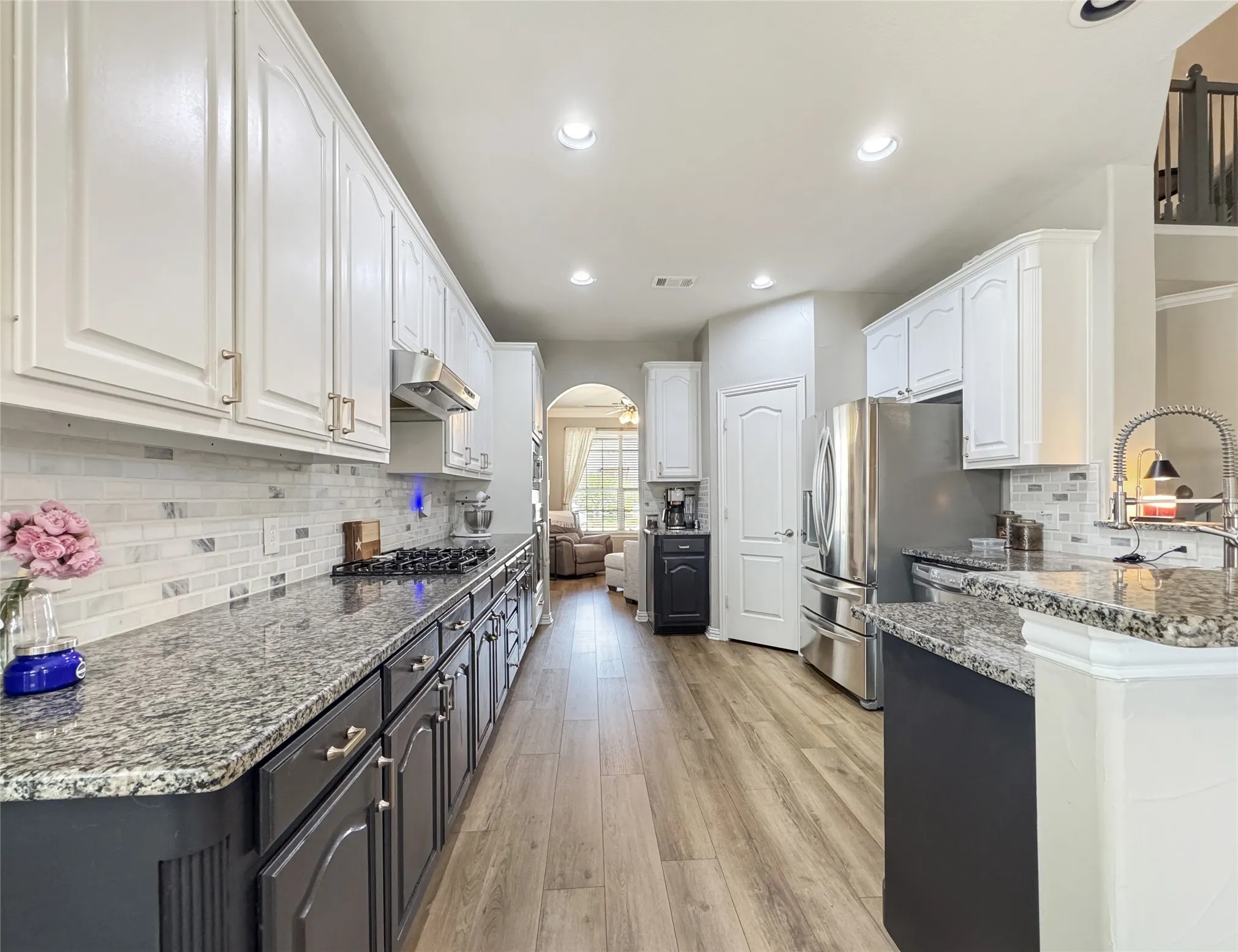 Wood-finish flooring with overhead cabinetry and a built-in shelf