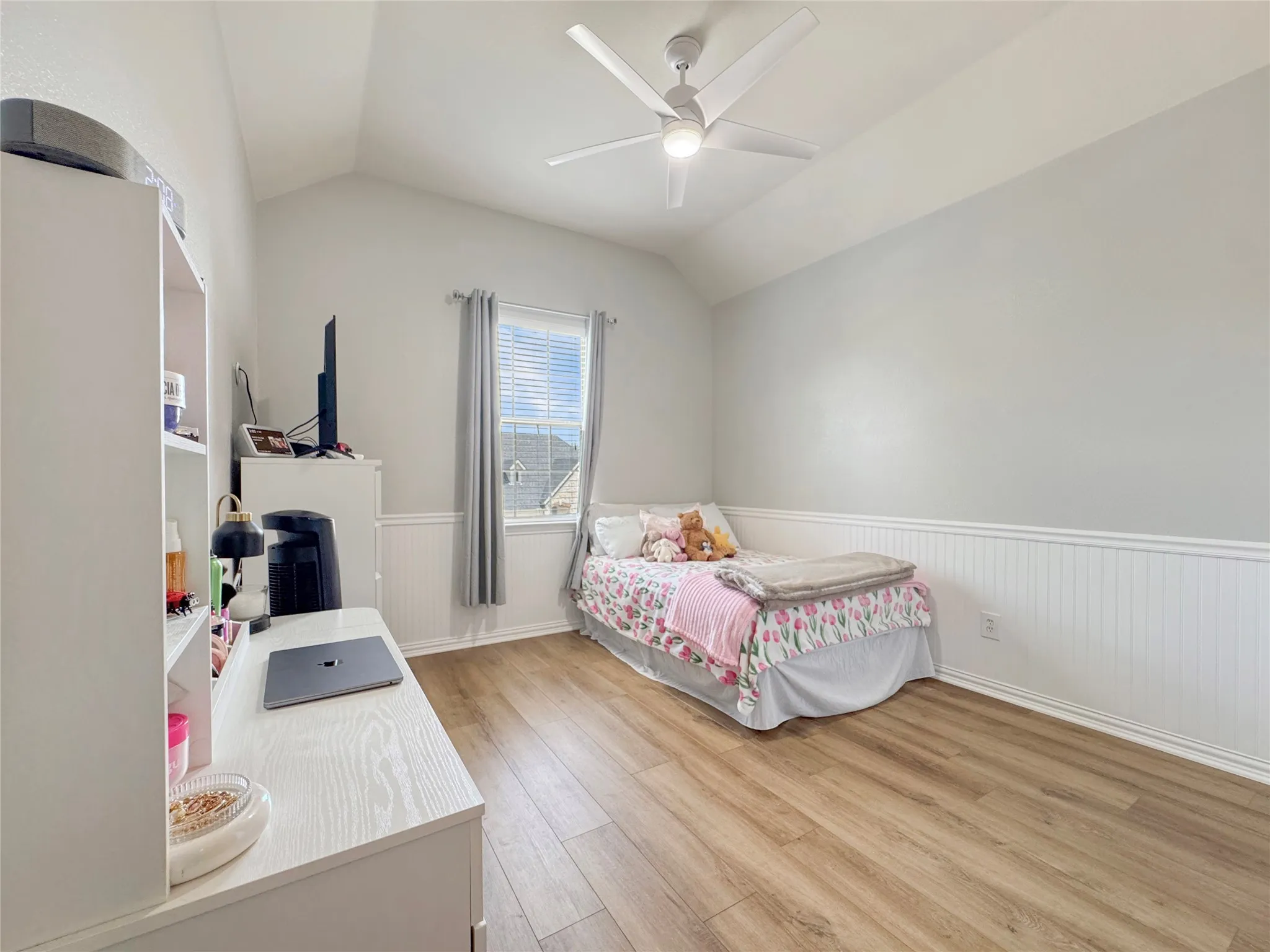 Wood-finish flooring, vaulted ceiling, ceiling fan, and white paneled doors