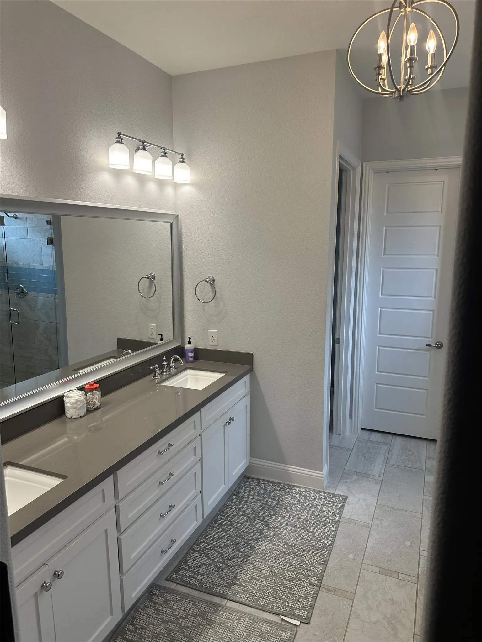 Dual vanity with white cabinetry, gray countertop, and undermount sinks