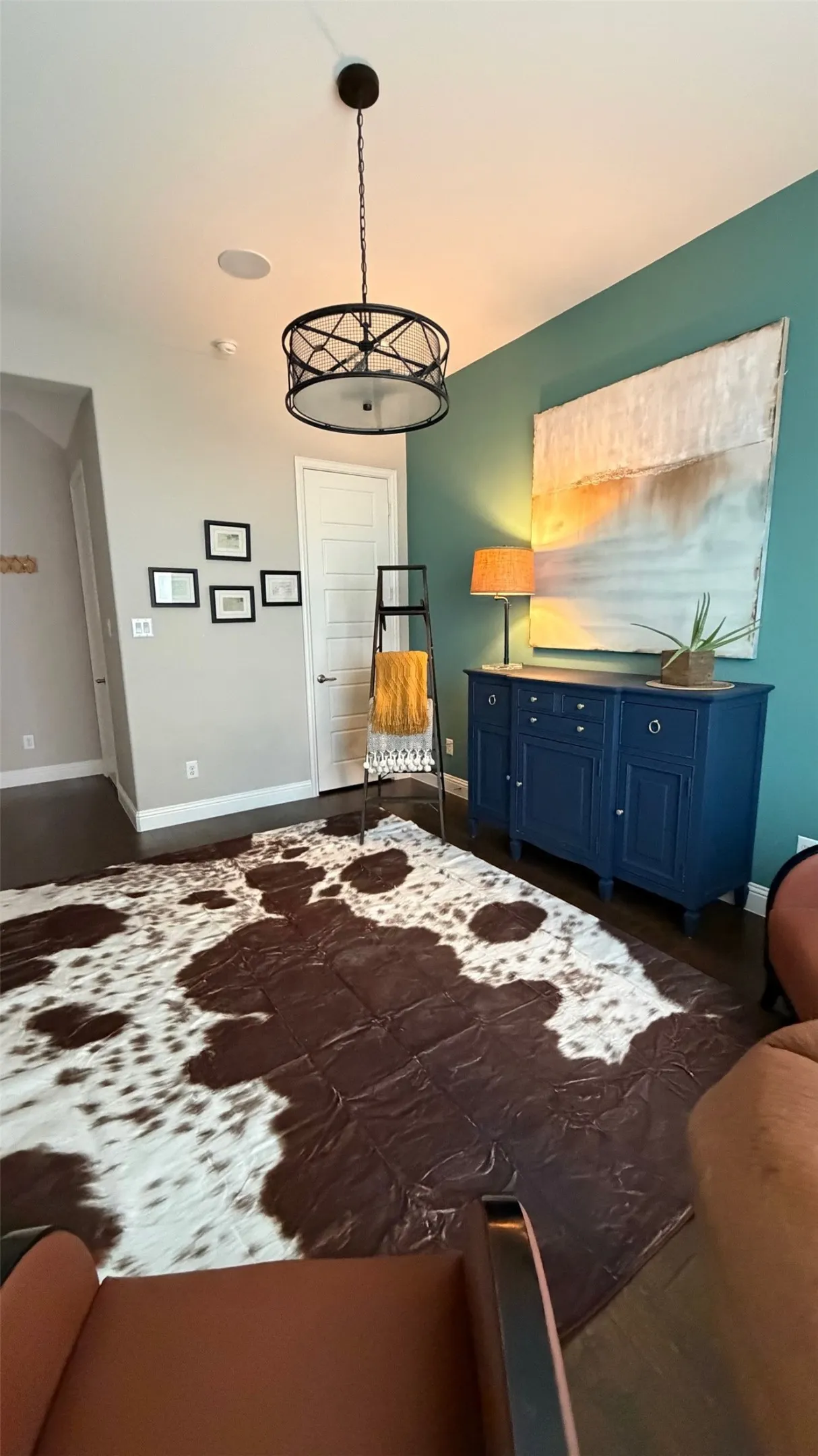 Wood-finish flooring with varying wall colors and a paneled door