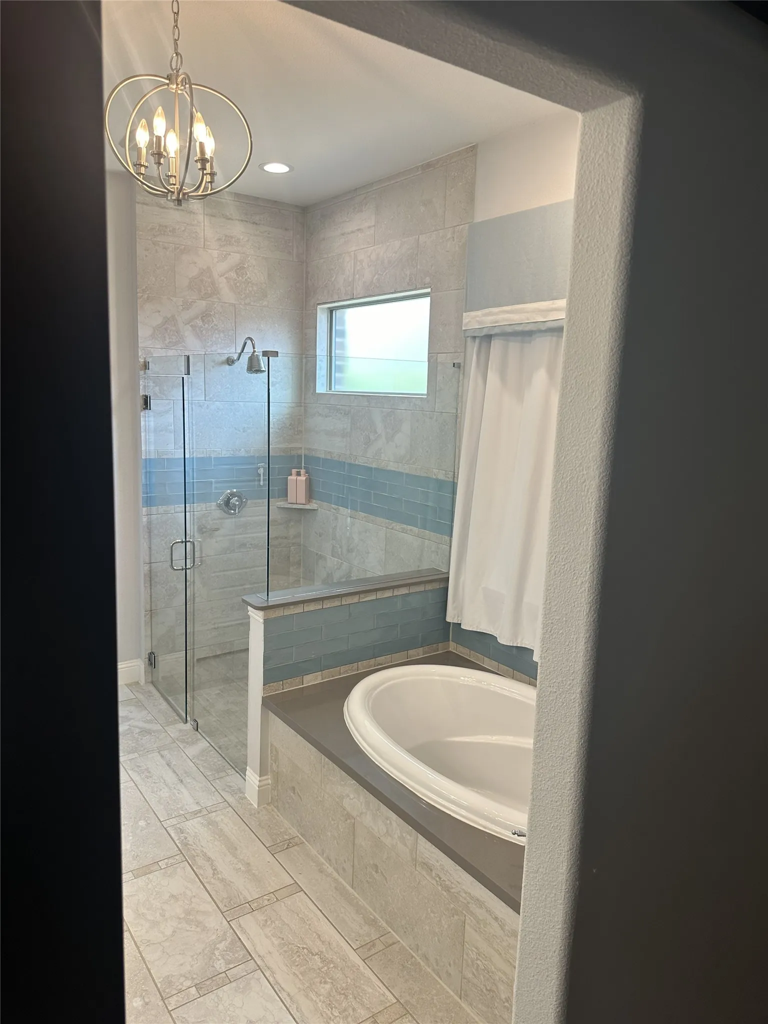 Spacious bathroom featuring a built-in soaking tub, a walk-in shower with glass enclosure, a vanity light fixture, recessed lighting, and tile flooring