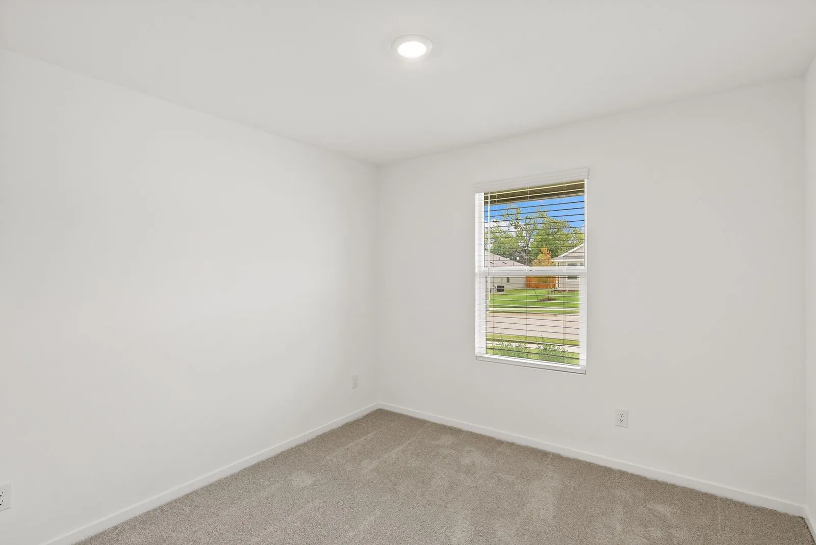 Recessed ceiling lighting, light gray wall-to-wall carpeting, window with blinds, and white painted walls