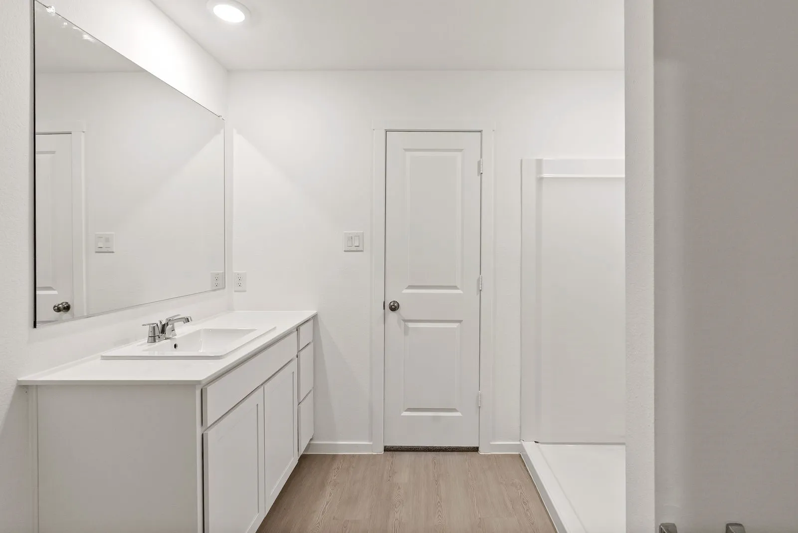 Vanity with an integrated sink, polished chrome faucet, and ample under-counter storage