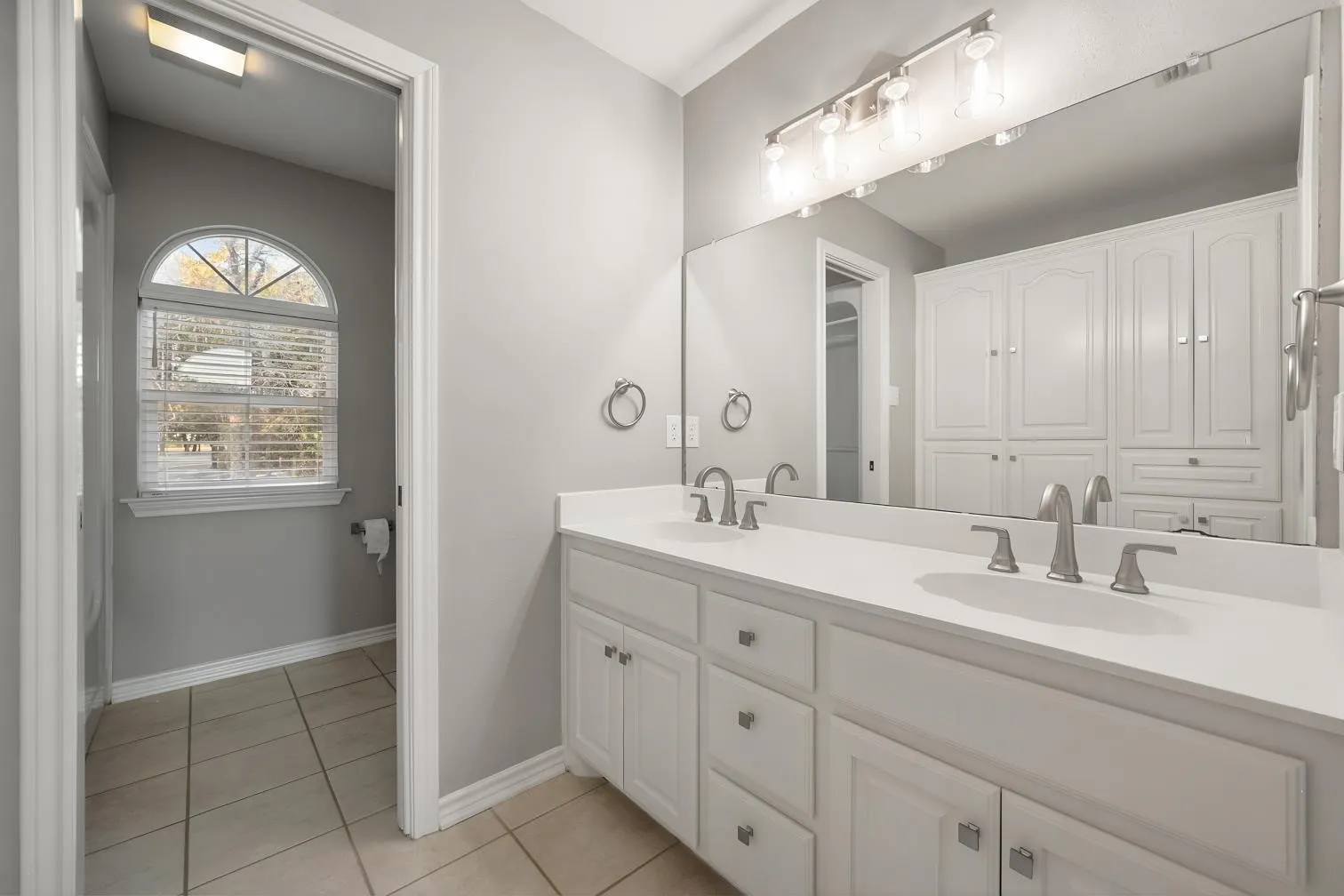 2nd floor full bathroom - Dual vanity with white cabinetry, solid surface countertop, and brushed nickel fixtures