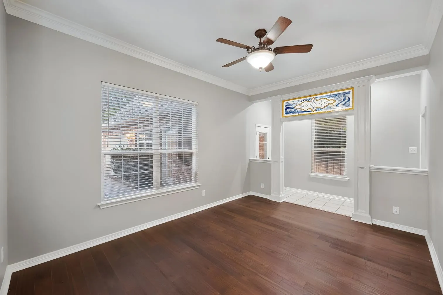 Engineered hardwood flooring, crown molding, ceiling fan with integrated lighting, and window with blinds