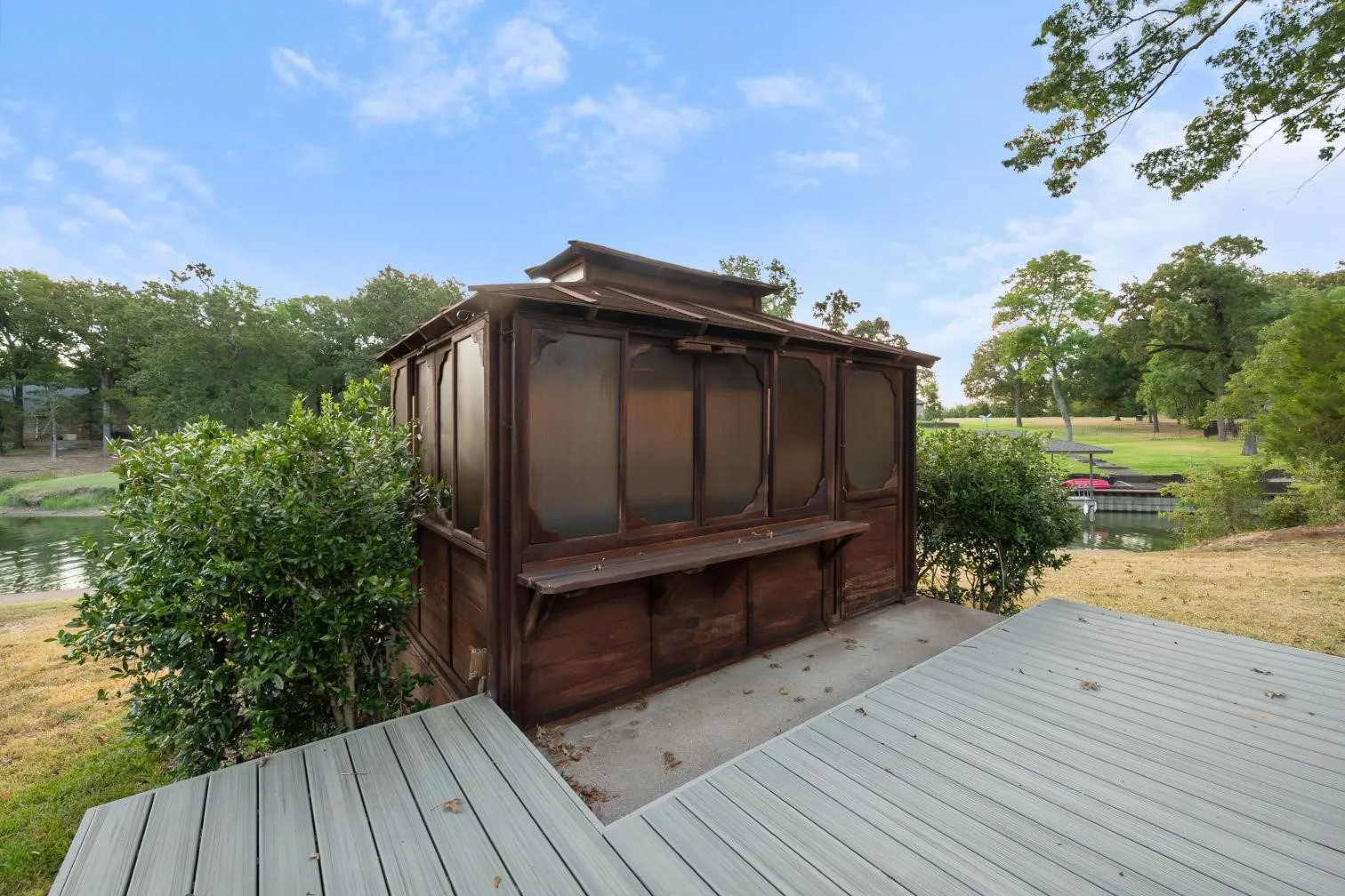 Wood-finish gazebo with an attached bar, composite decking, and a waterfront setting
