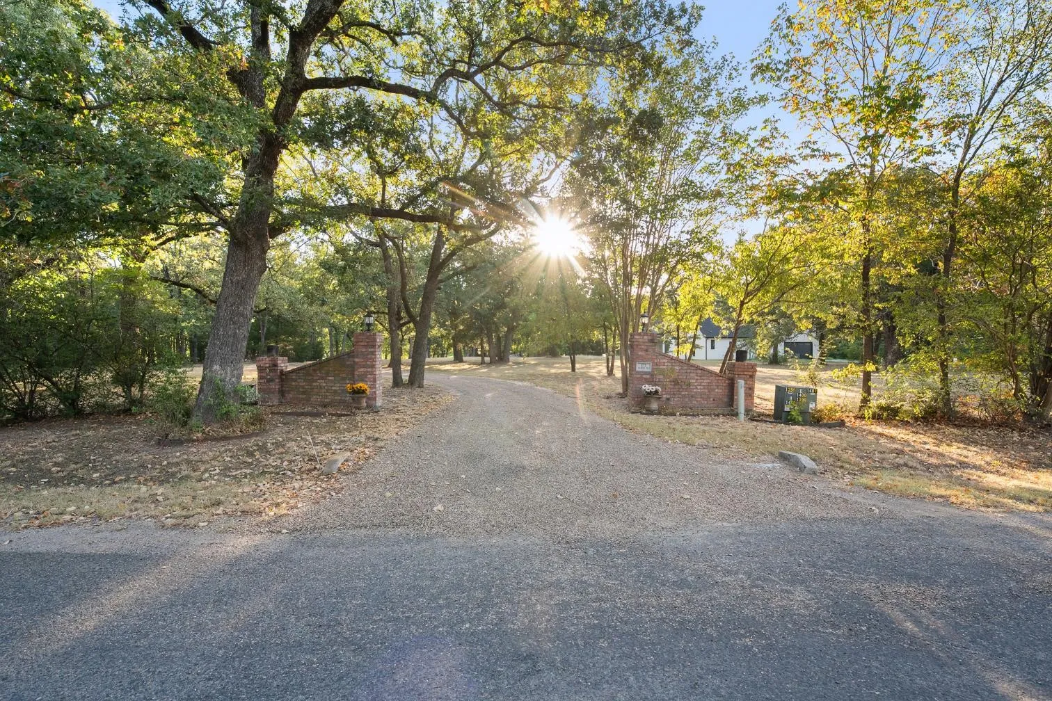 Gravel drive with brick column entry and mature trees