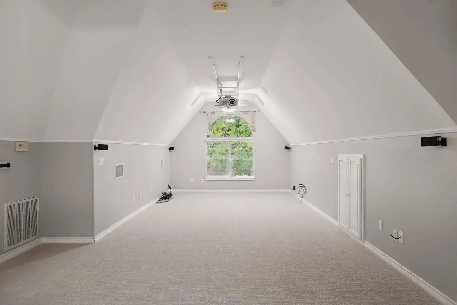 Spacious game room with vaulted ceilings and light-toned carpeting
