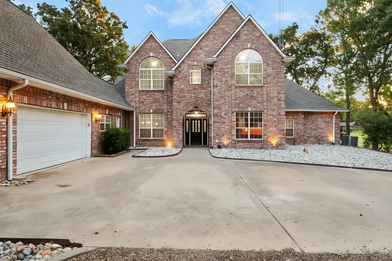 Brick exterior with arched windows and ground-level accent lighting