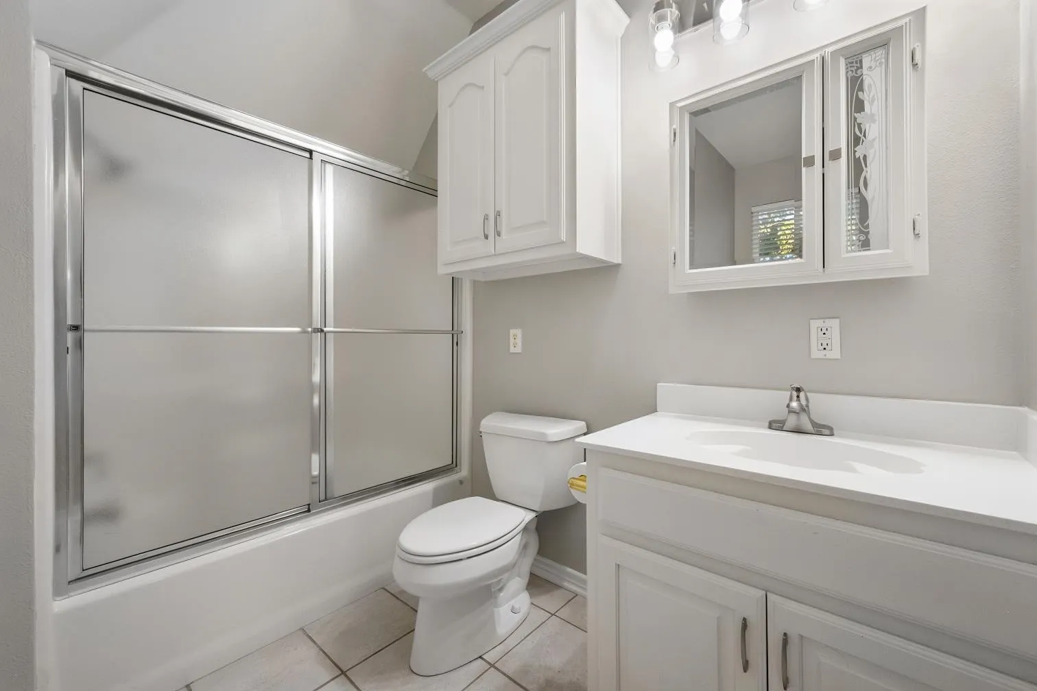 White vanity with integrated sink, chrome faucet, and white cabinetry