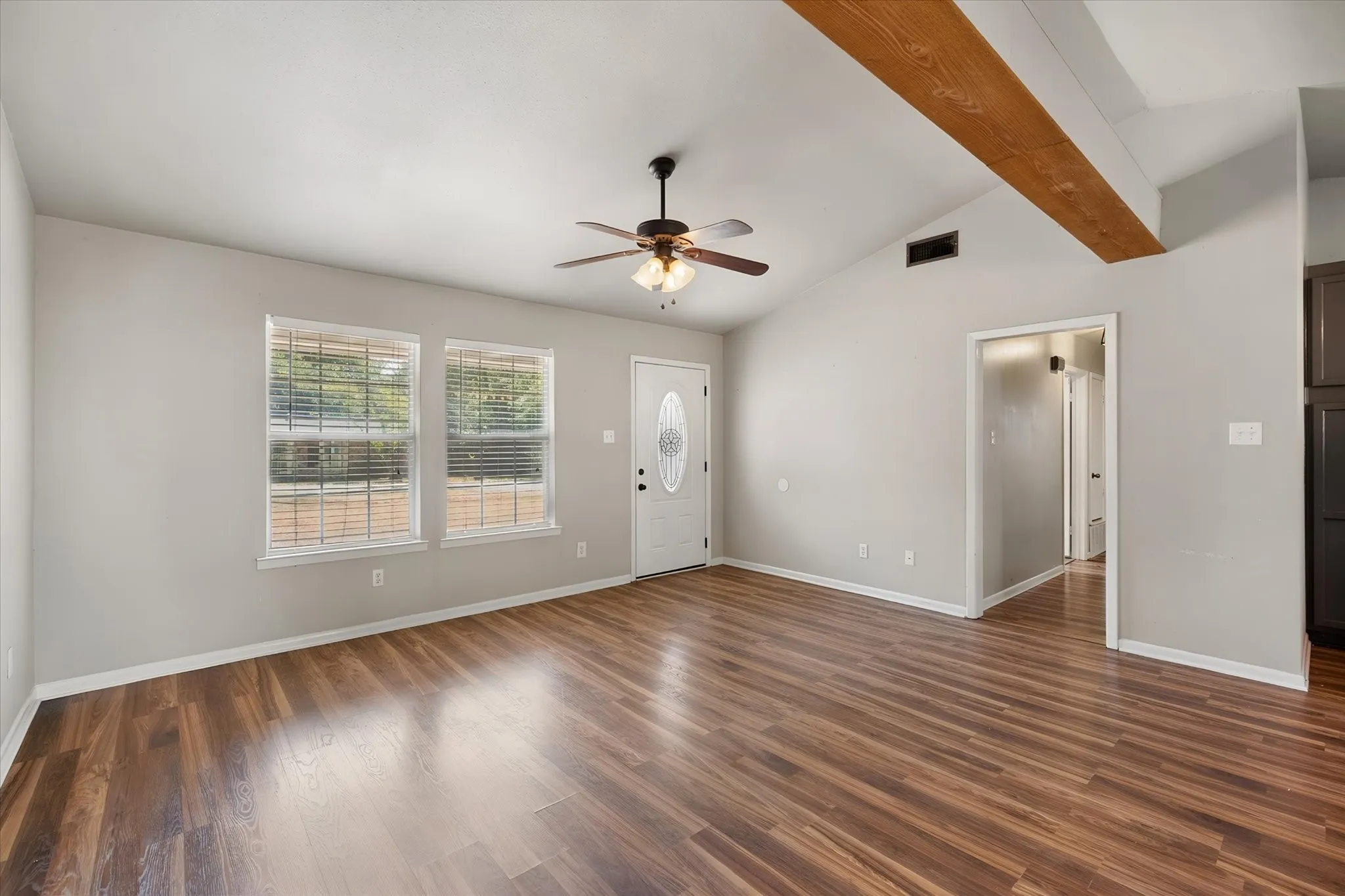 Living Room with vaulted ceiling and open to kitchen and dining area.