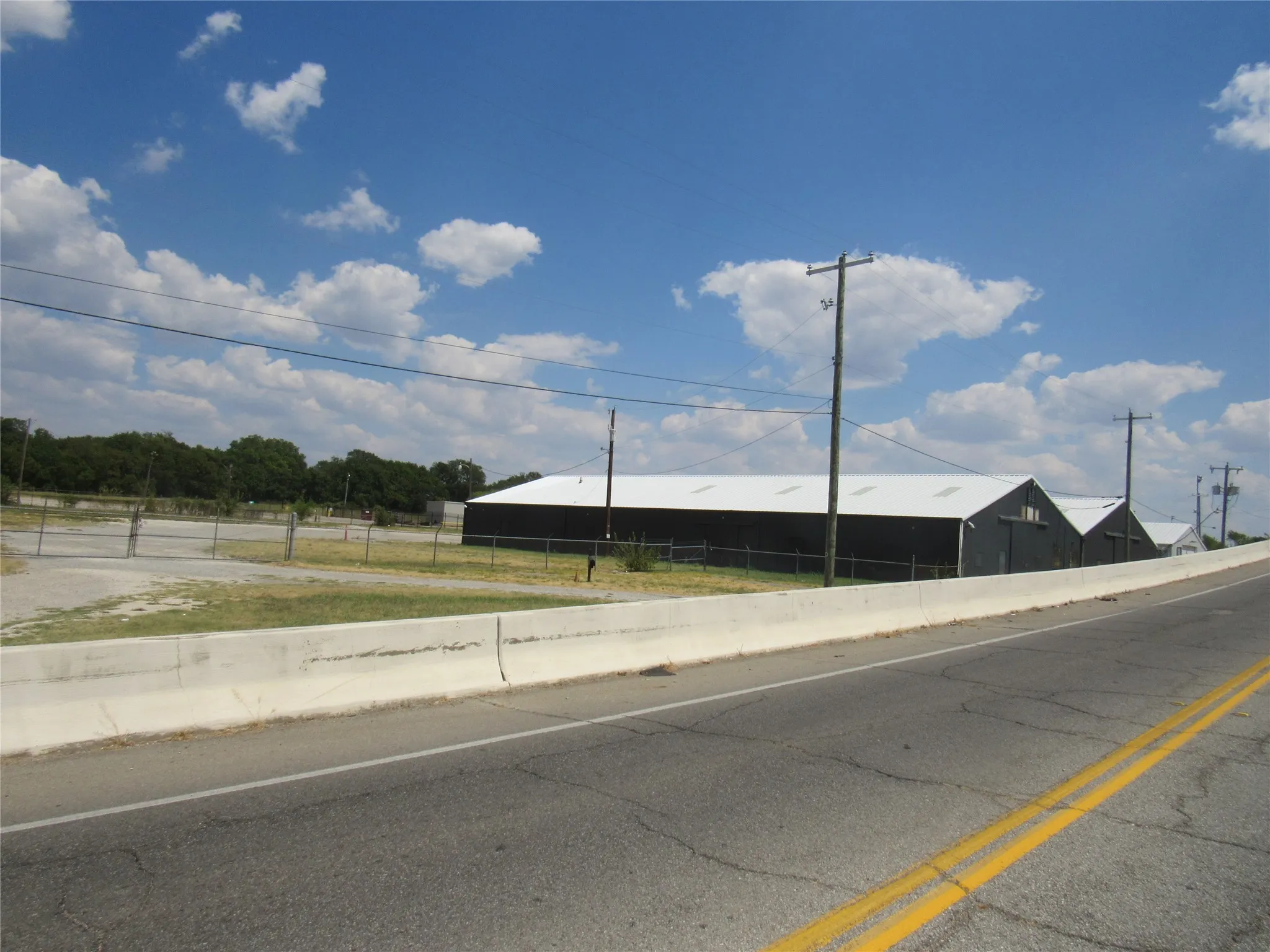 Industrial-style building with a dark facade and light-colored roof