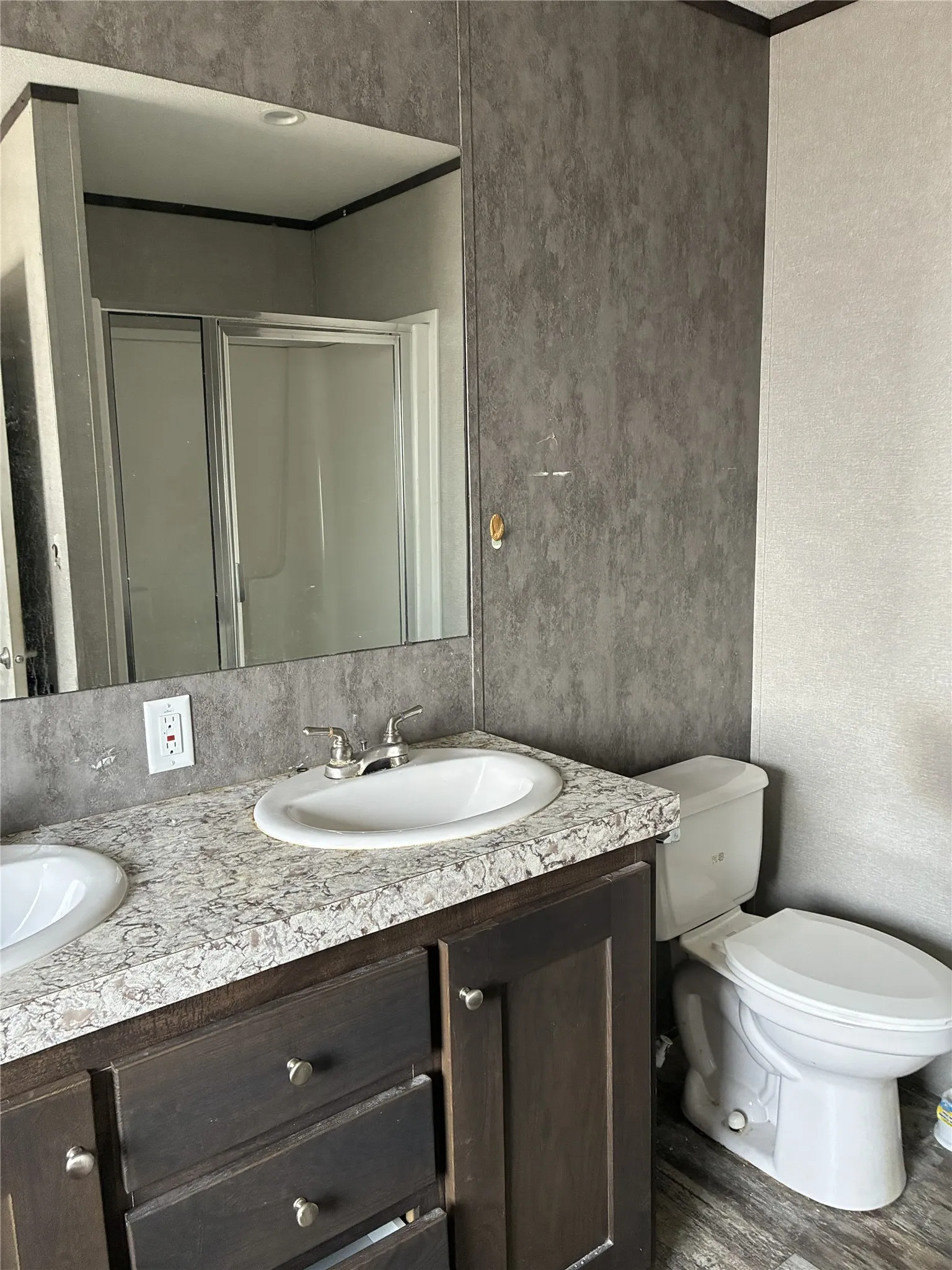 Dual vanity with oval sinks, brushed nickel faucets, and a speckled countertop