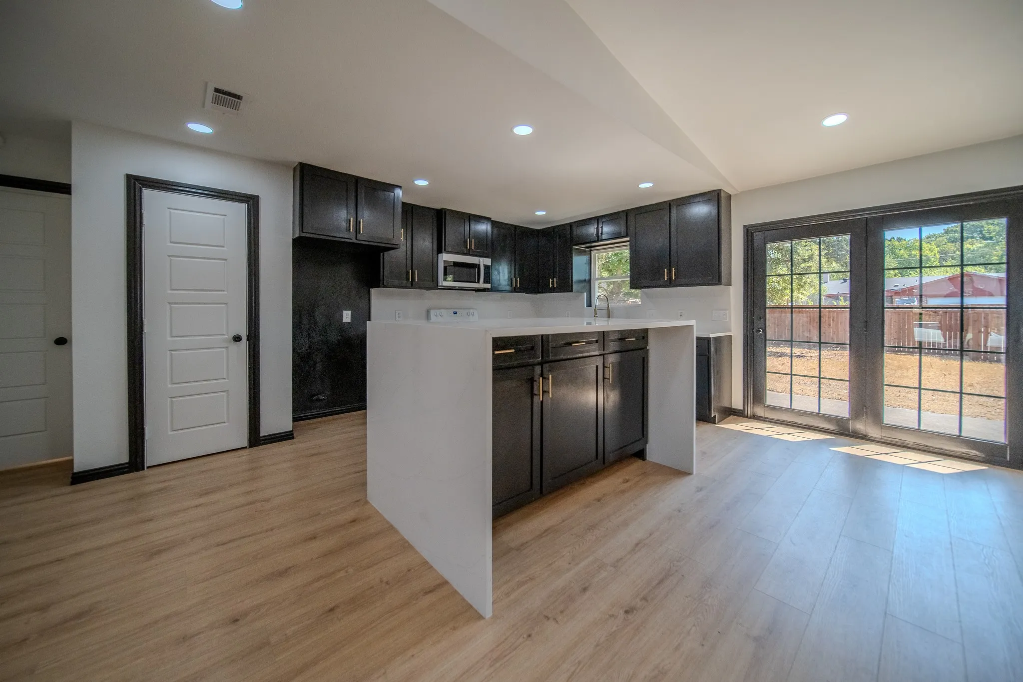 Kitchen featuring dark cabinetry, a center island with a white countertop, recessed lighting, and wood-finish flooring