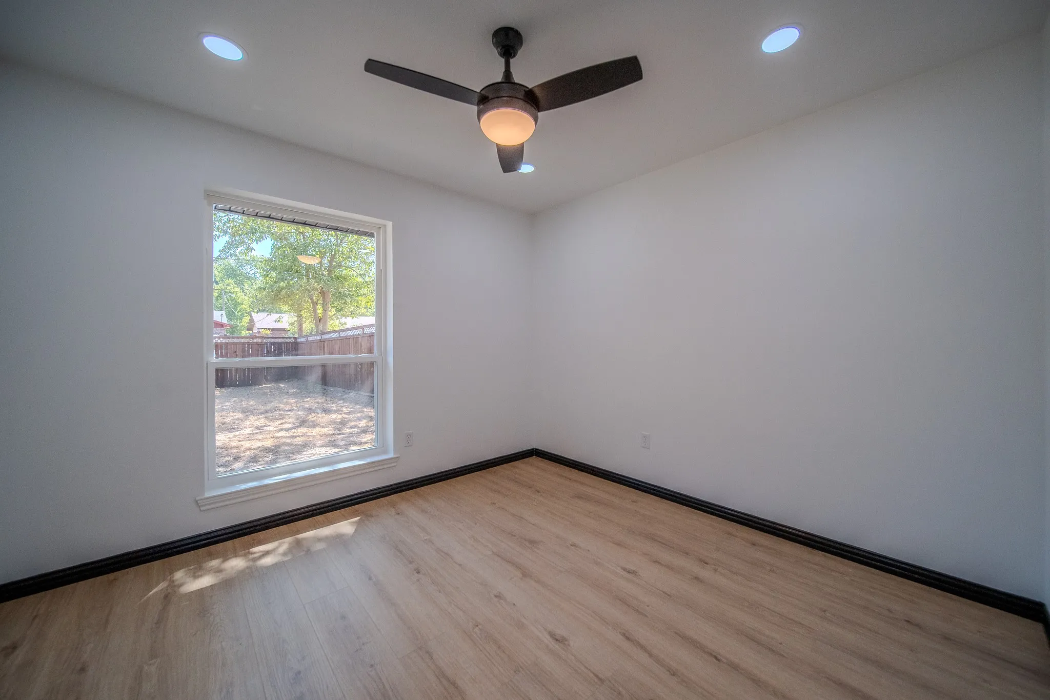 Wood-finish flooring, recessed lighting, and a ceiling fan with integrated light fixture
