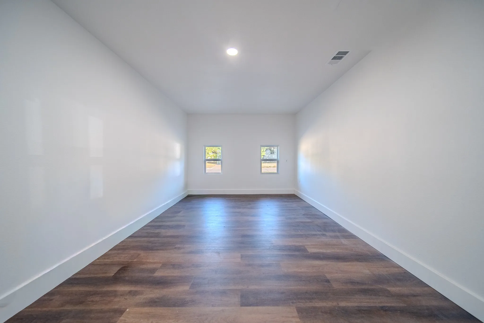 Wood-finish flooring, recessed ceiling lighting, and twin windows