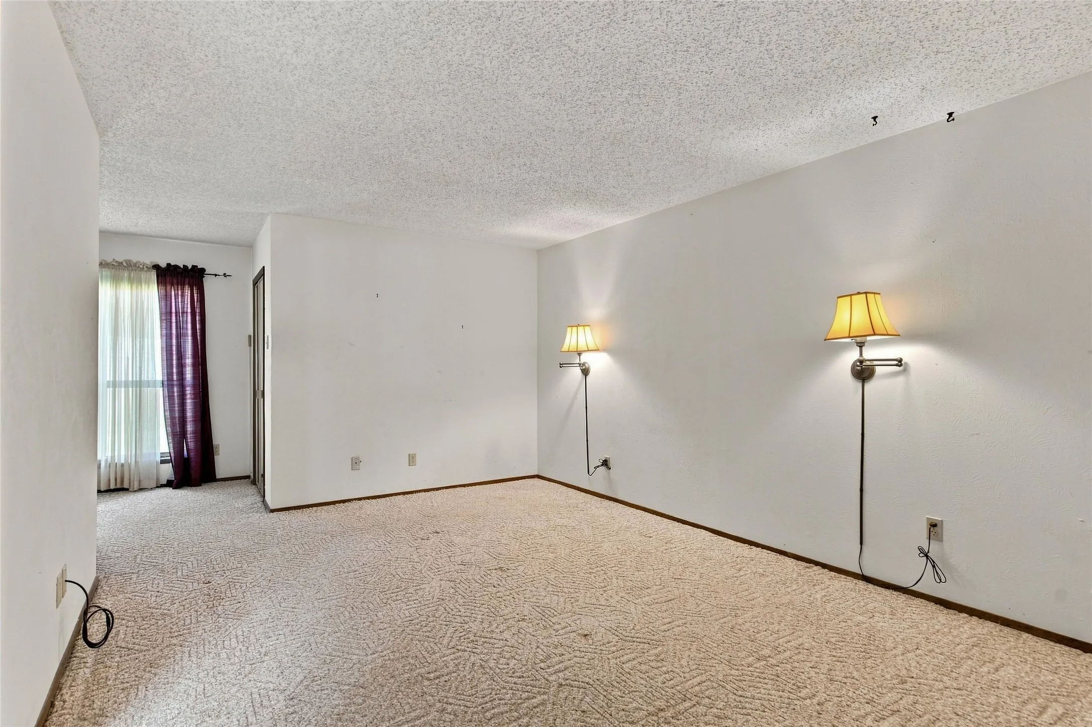 Wall-mounted sconces illuminate the carpeted interior with a textured ceiling