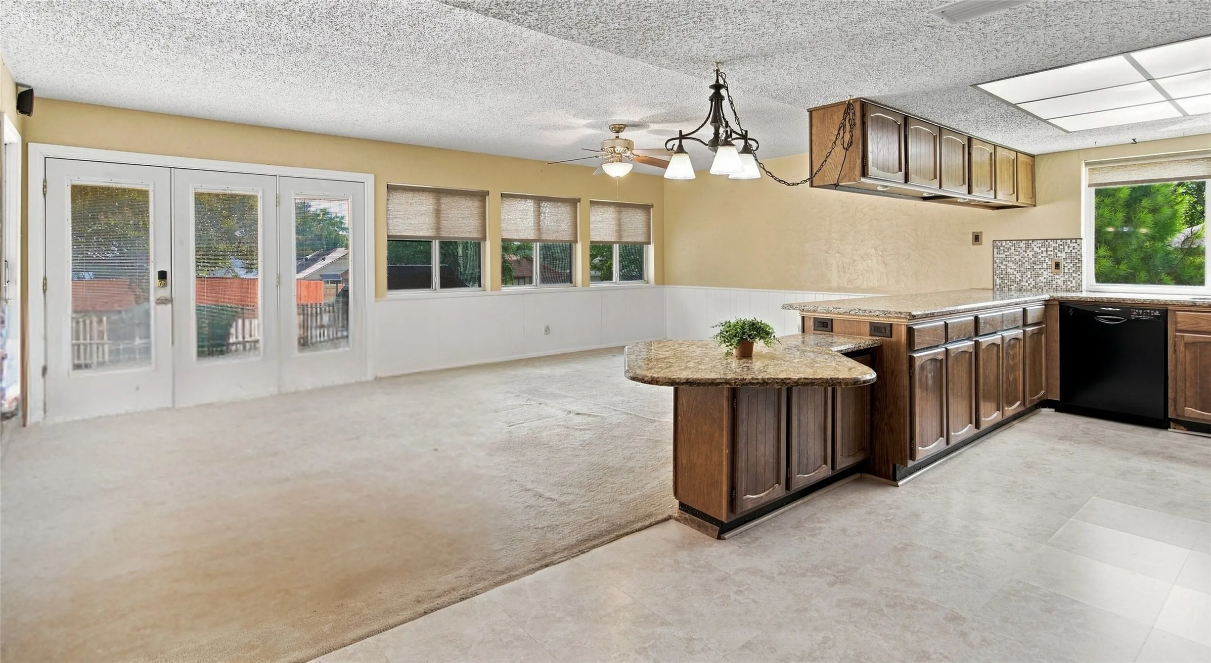 Kitchen with wood cabinetry, light countertops, and tile backsplash
