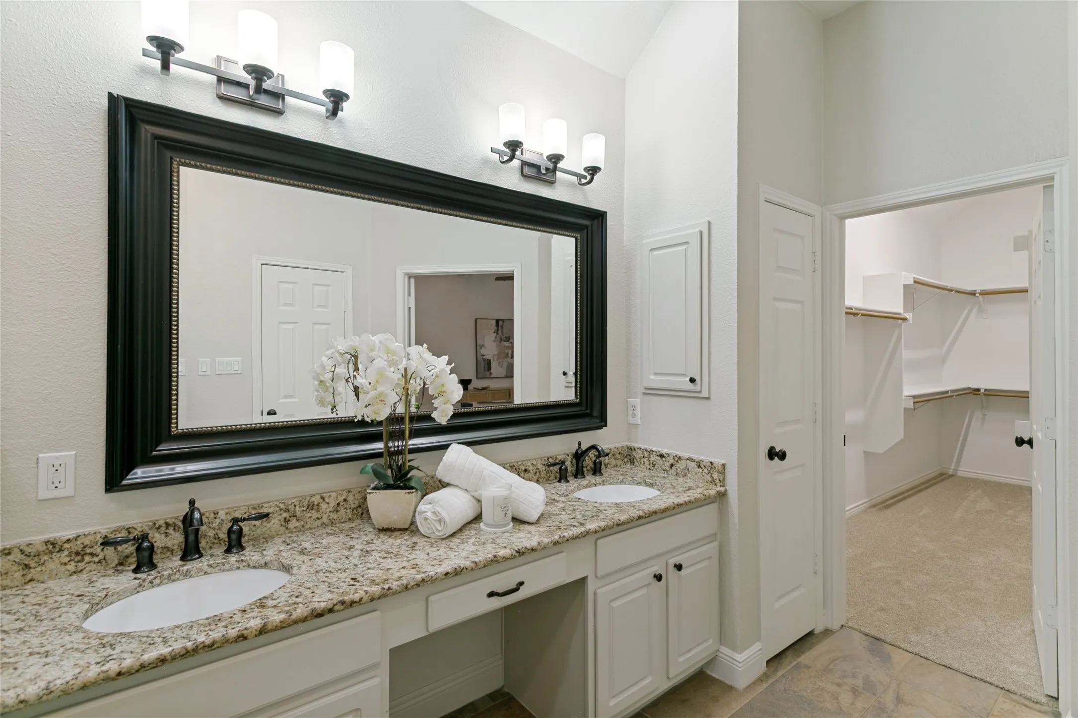Double vanity with granite-style countertop, dual undermount sinks, and oil-rubbed bronze fixtures