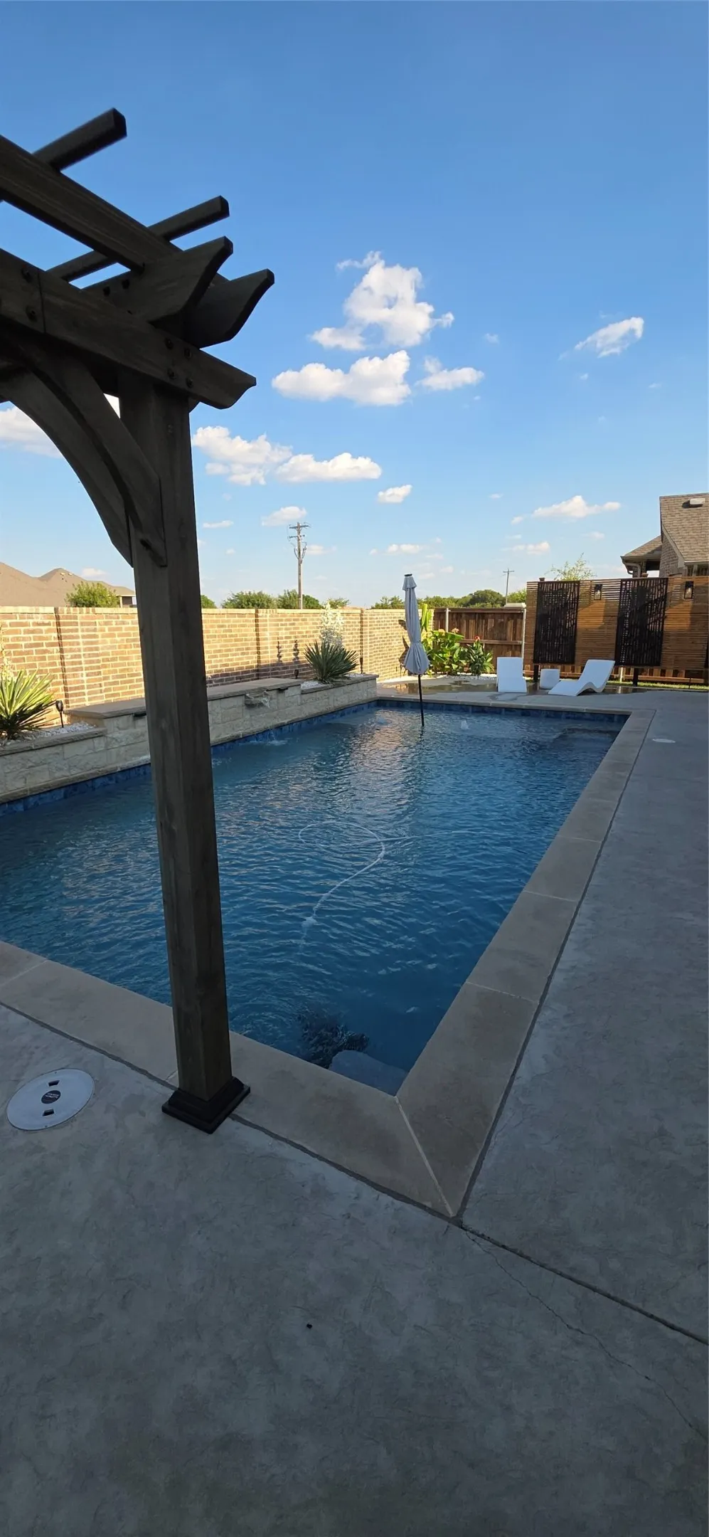 Outdoor pool with a stone coping and a surrounding concrete patio