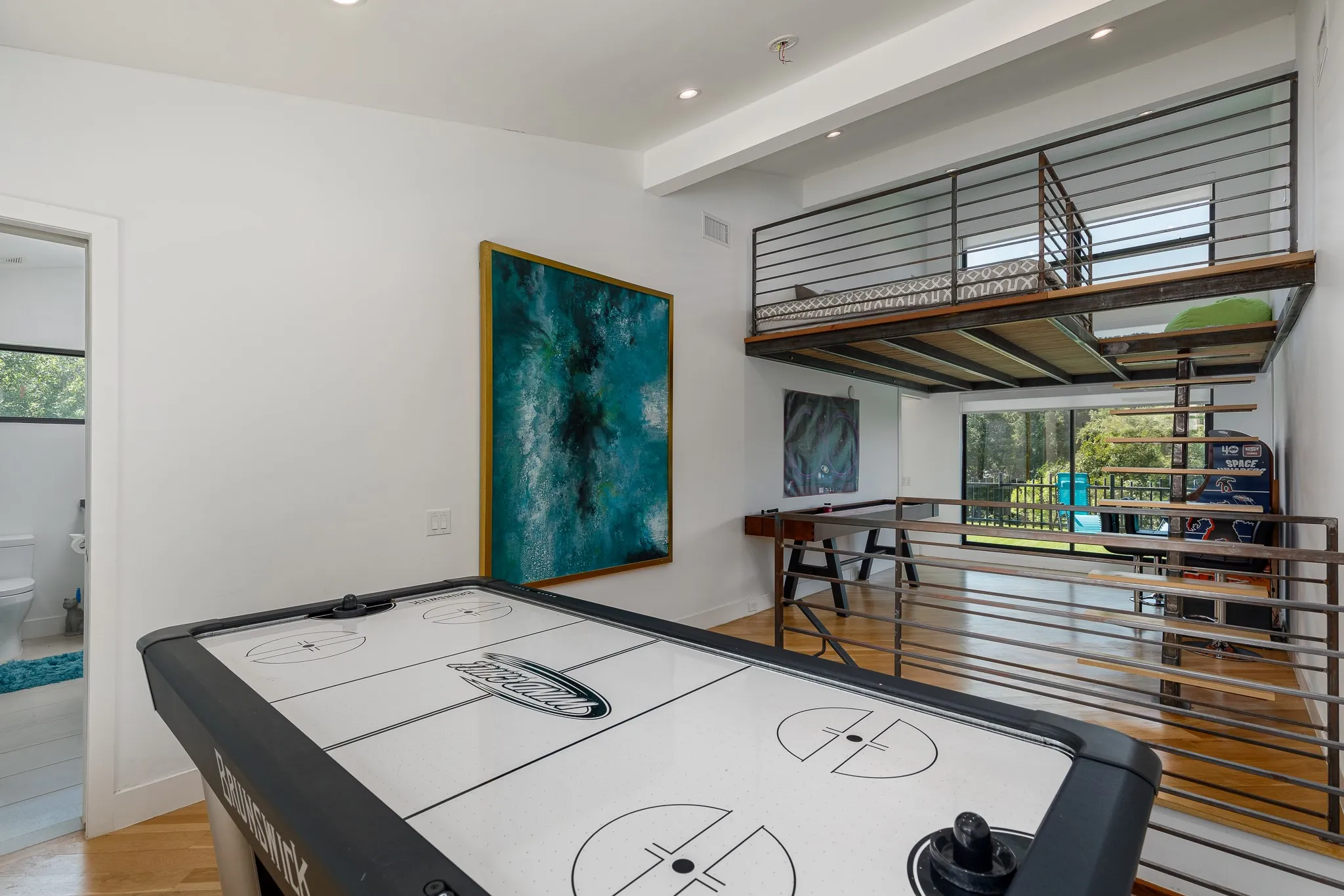 High ceilings with recessed lighting, a lofted space featuring metal railings, and wood-finish flooring throughout