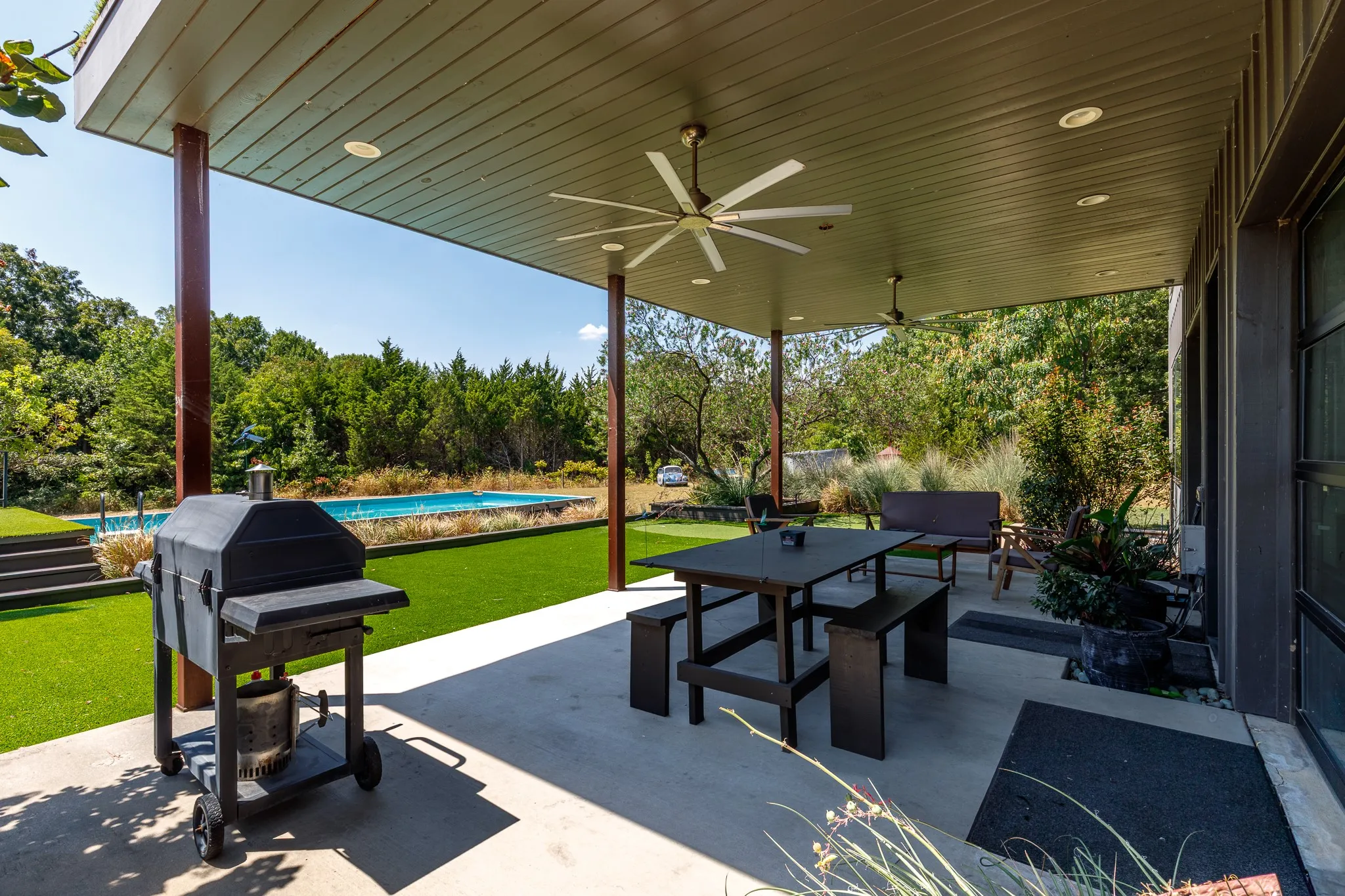 Covered patio with integrated ceiling fans, recessed lighting, and expansive concrete flooring