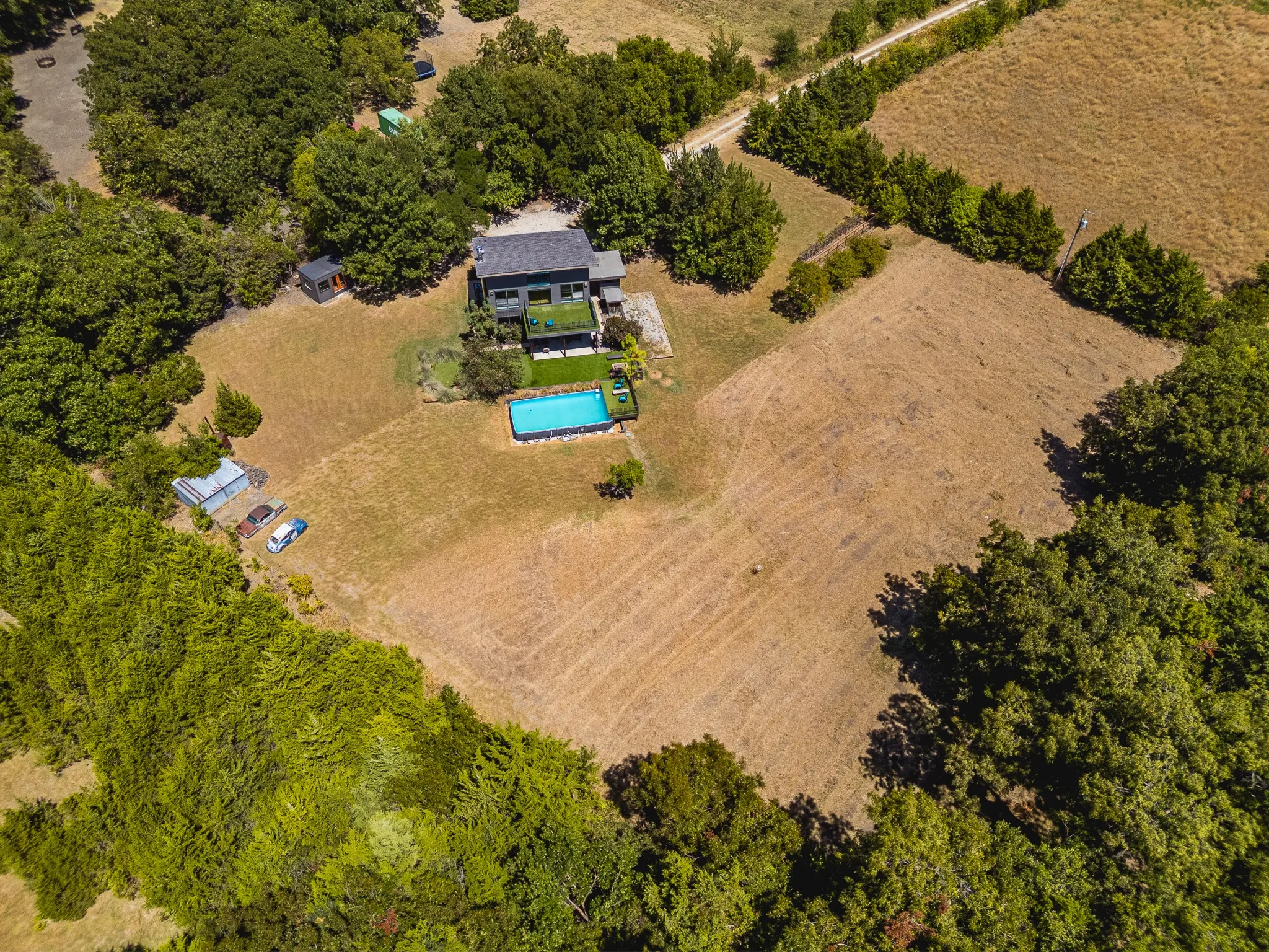 Property featuring a contemporary exterior, an in-ground swimming pool, and extensive surrounding land