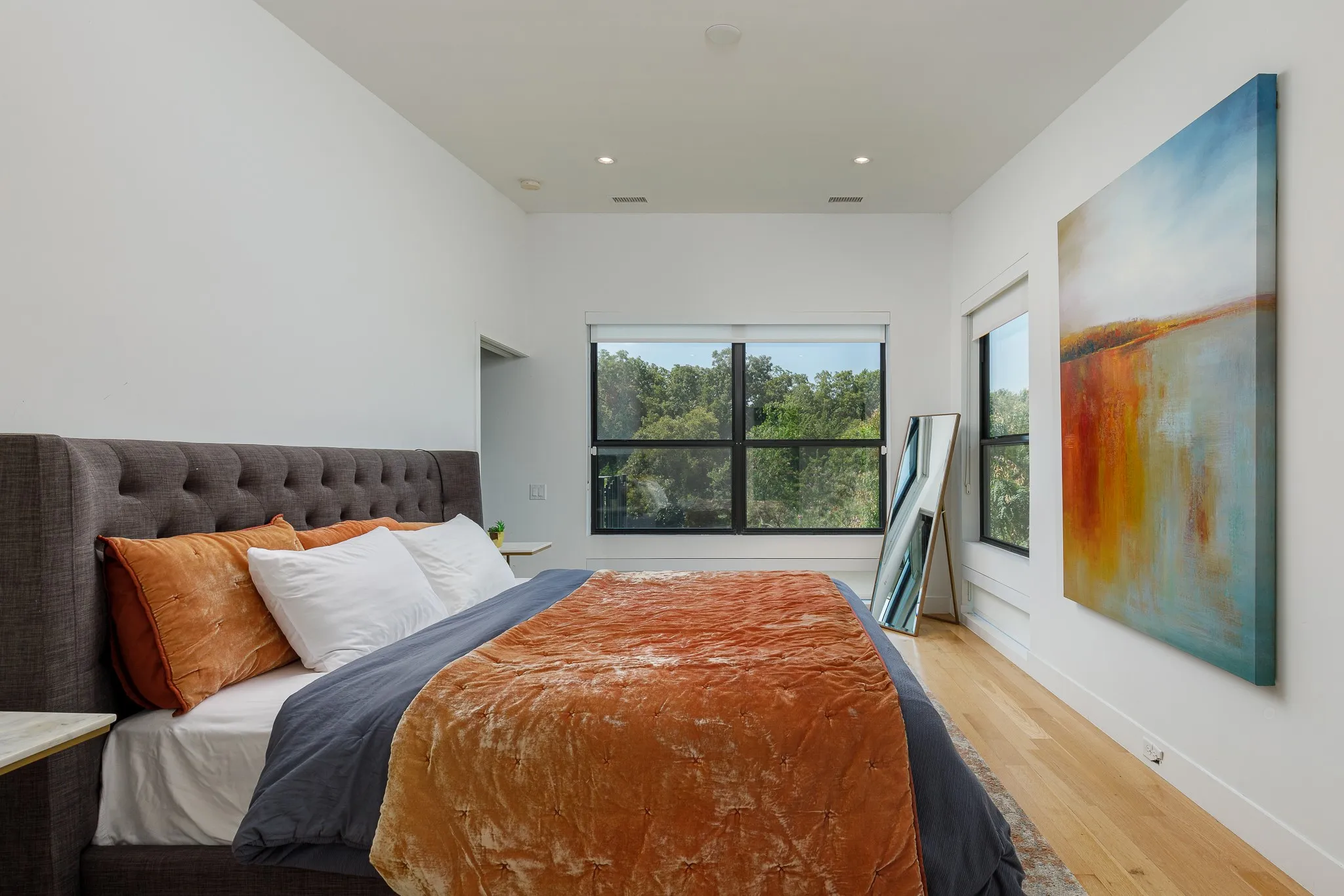 High ceilings, recessed lighting, light wood-finish flooring, and large windows with black frames