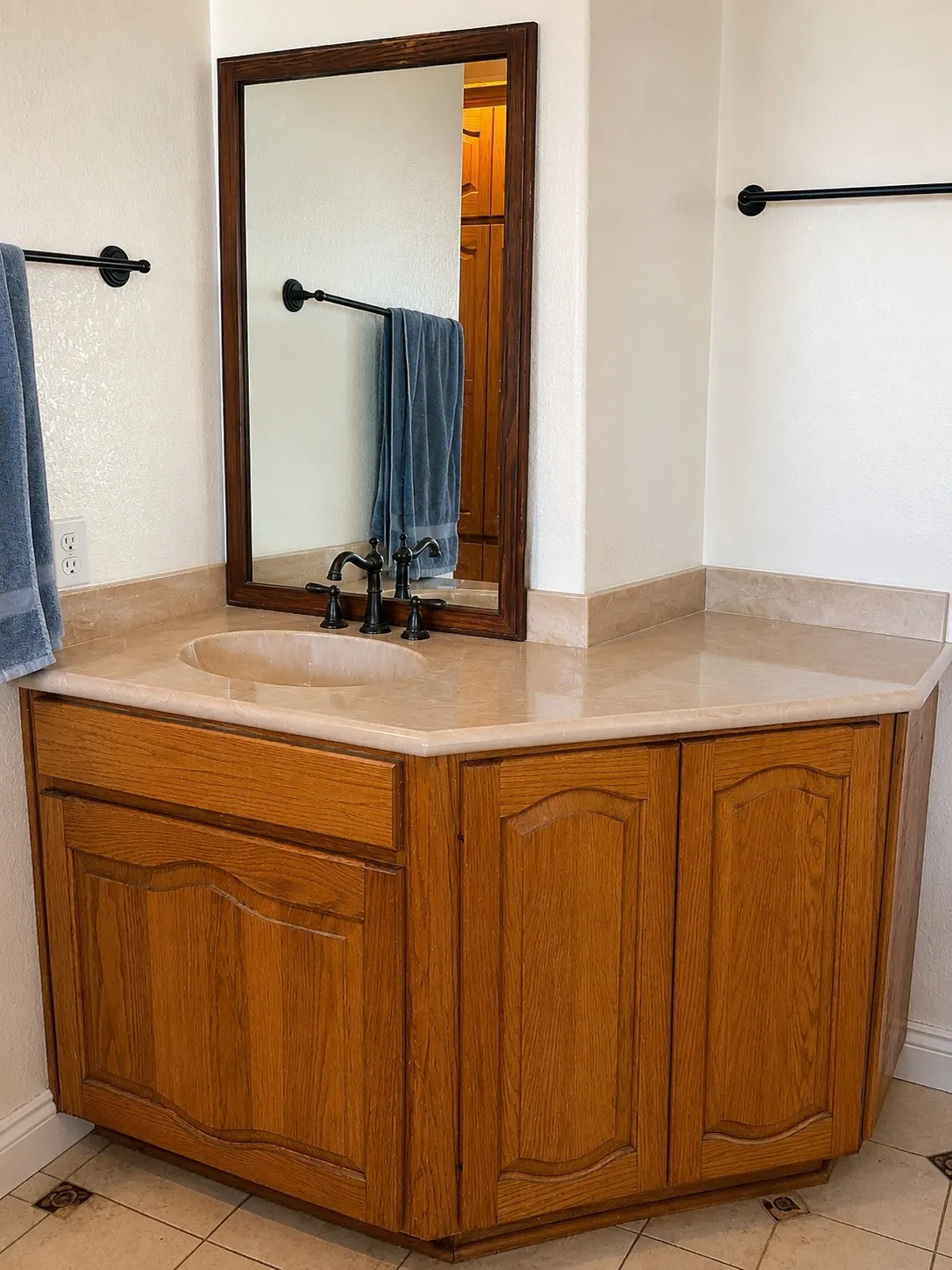 Built-in vanity with a stone countertop, integrated sink, and an oil-rubbed bronze faucet