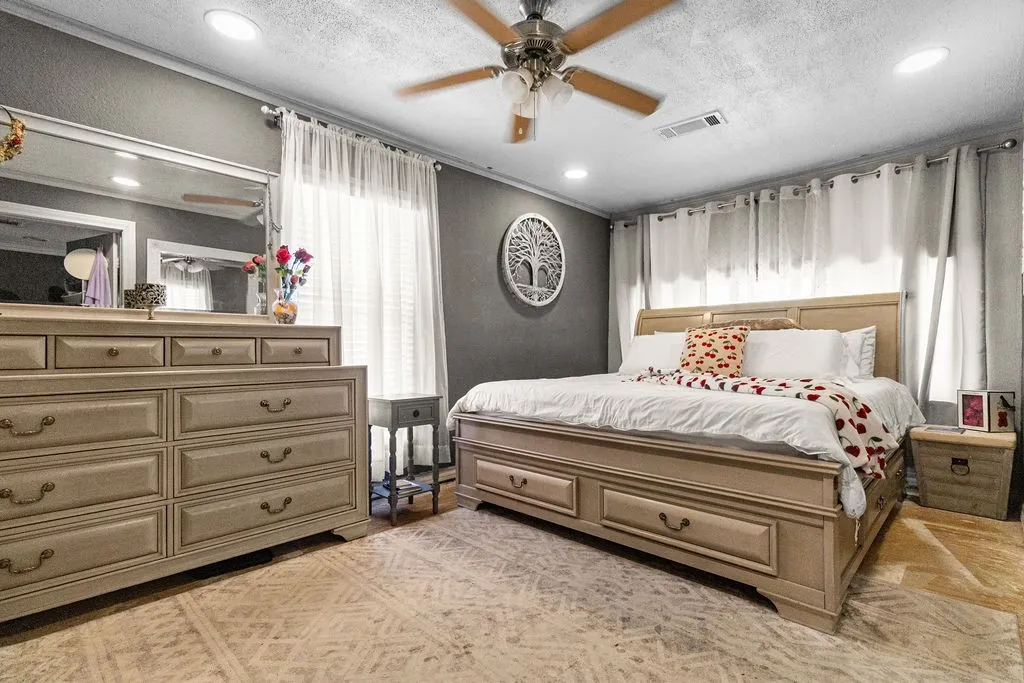 Recessed ceiling lighting, ceiling fan, dark accent wall, and window with privacy blinds