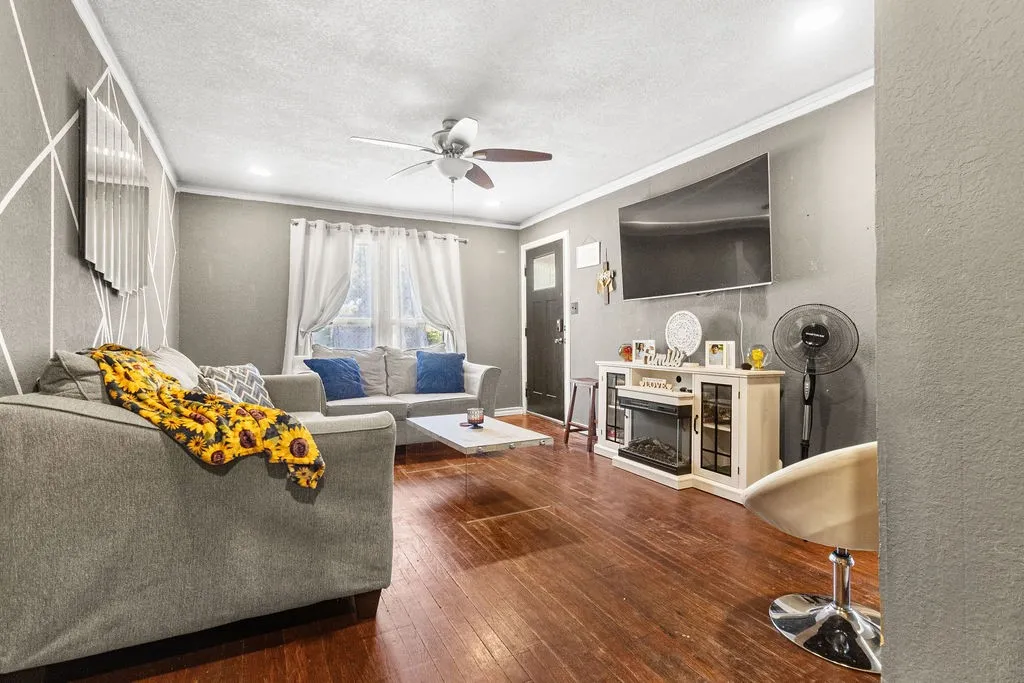 Warm wood-finish flooring, ceiling fan, recessed lighting, and a front entry door with a frosted glass panel